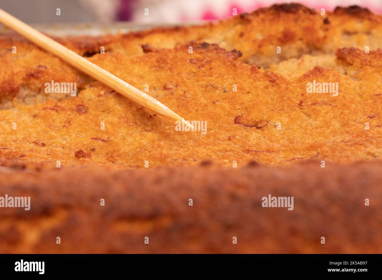 Spiedino su una torta per verificare se è cucinato attraverso Foto Stock