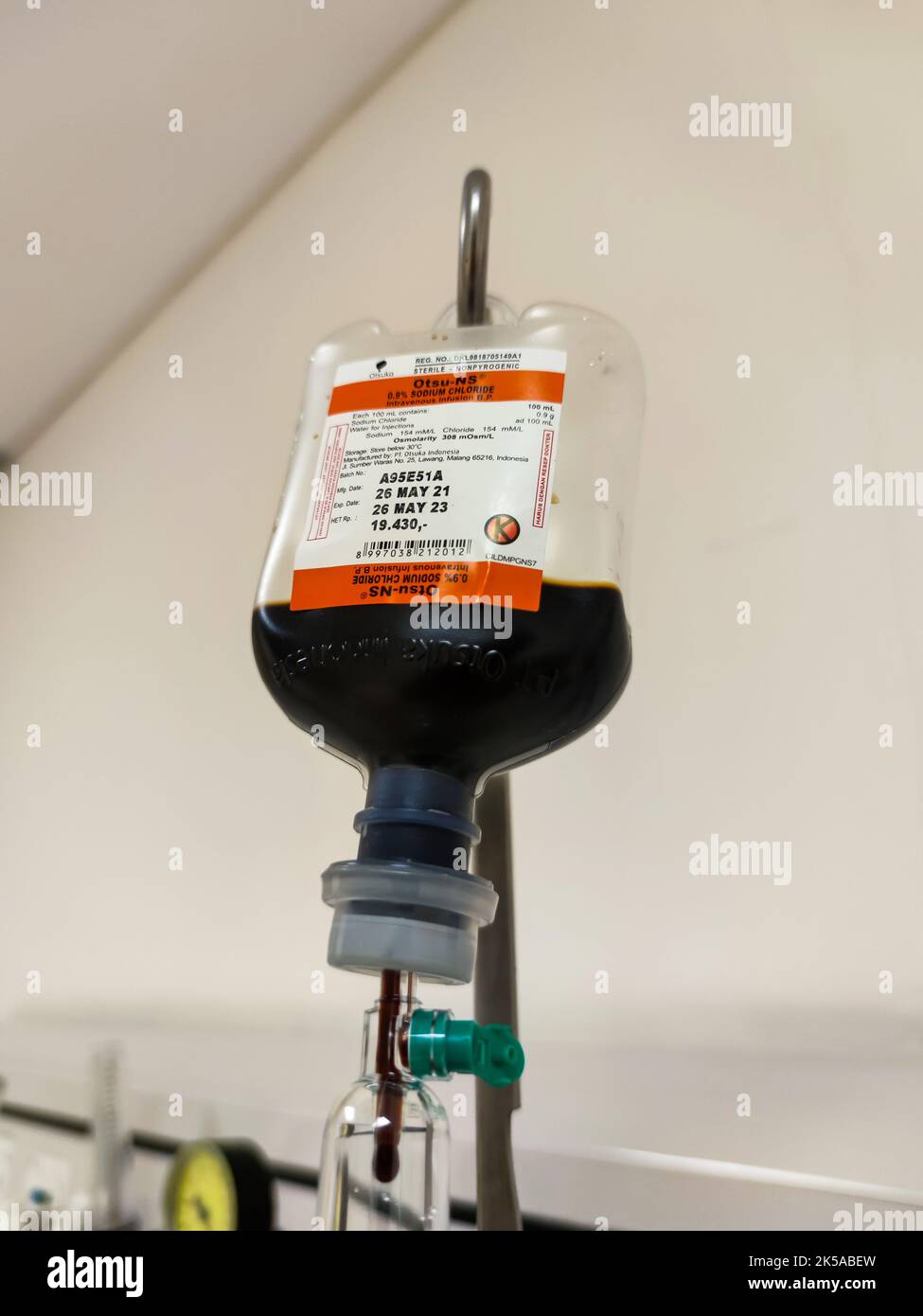 Primo piano del sacchetto di plastica per infusione endovenosa con camera di gocciolamento in sala risveglio presso l'unità di terapia intensiva dell'ospedale con sfondo bokeh. Nessuna gente. Foto Stock