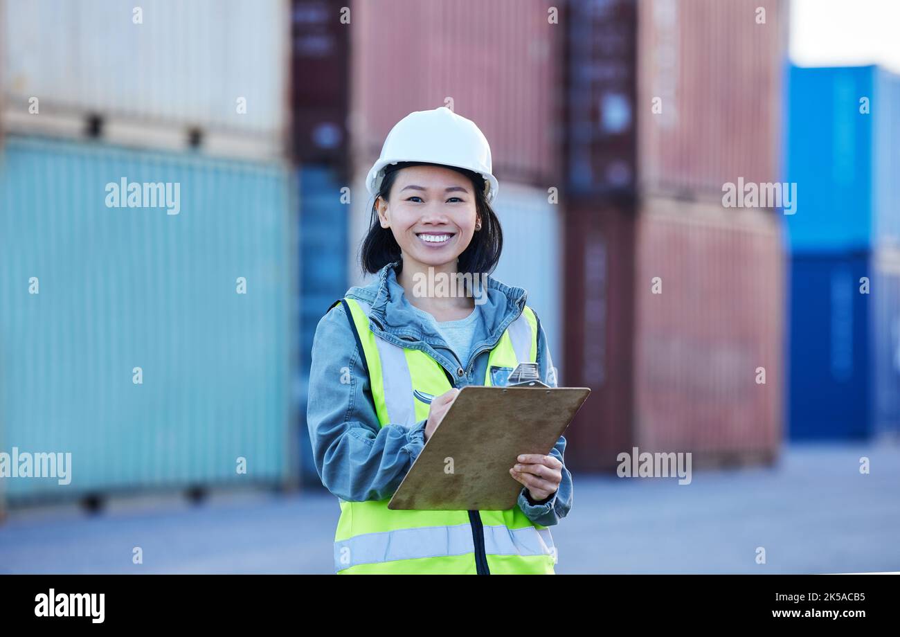 Donna con appunti, spedizione e controllo logistico delle scorte in cantiere. Lavoratore asiatico nel settore dei trasporti, sorriso in ritratto con contenitore in Foto Stock