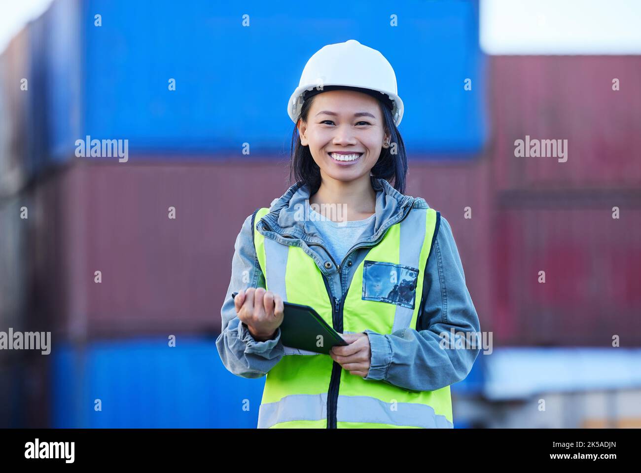 Logistica, asiatica e donna con tablet, container e controlla la consegna di merci, prodotti o dati di magazzino. Supply chain, sorriso e ritratto di Foto Stock