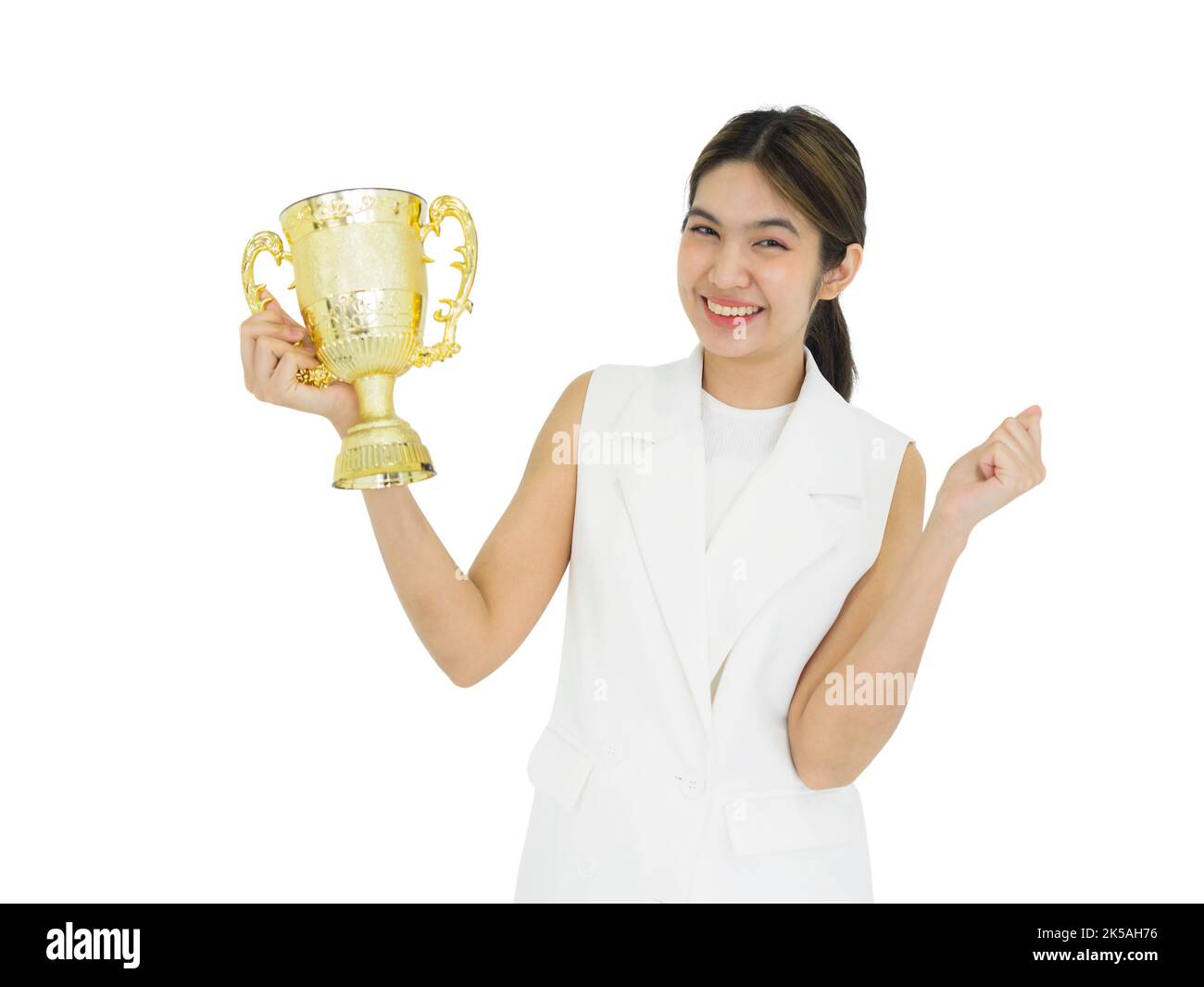 Donna asiatica in vestito bianco che tiene il trofeo ricevuto dal lavoro fatto con orgoglio. Ritratto su sfondo bianco con luce da studio. Foto Stock