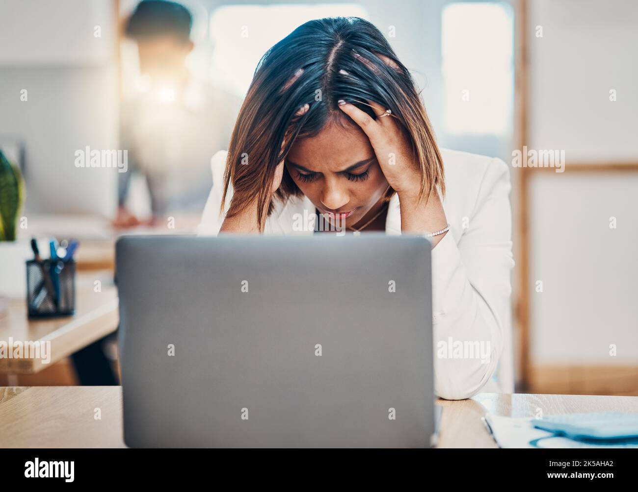 Mal di testa, stress e donna d'affari con burnout da problemi di lavoro su un notebook in ufficio. Triste, stanco e lavoratore corporativo indiano con ansia mentre Foto Stock