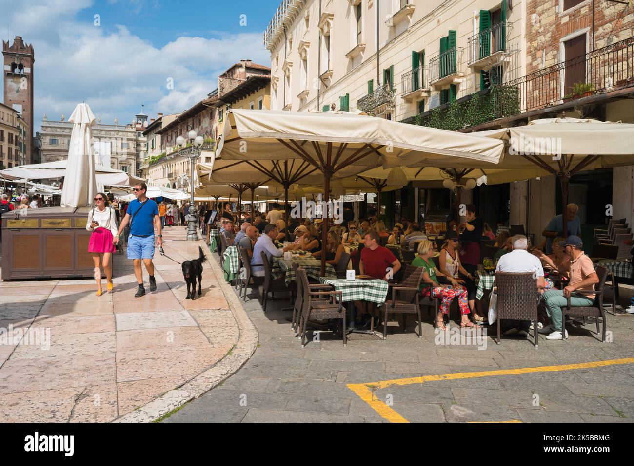 Piazza delle Erbe, vista in estate di persone sedute fuori caffè e bar in Piazza delle Erbe nel centro storico di Verona Foto Stock