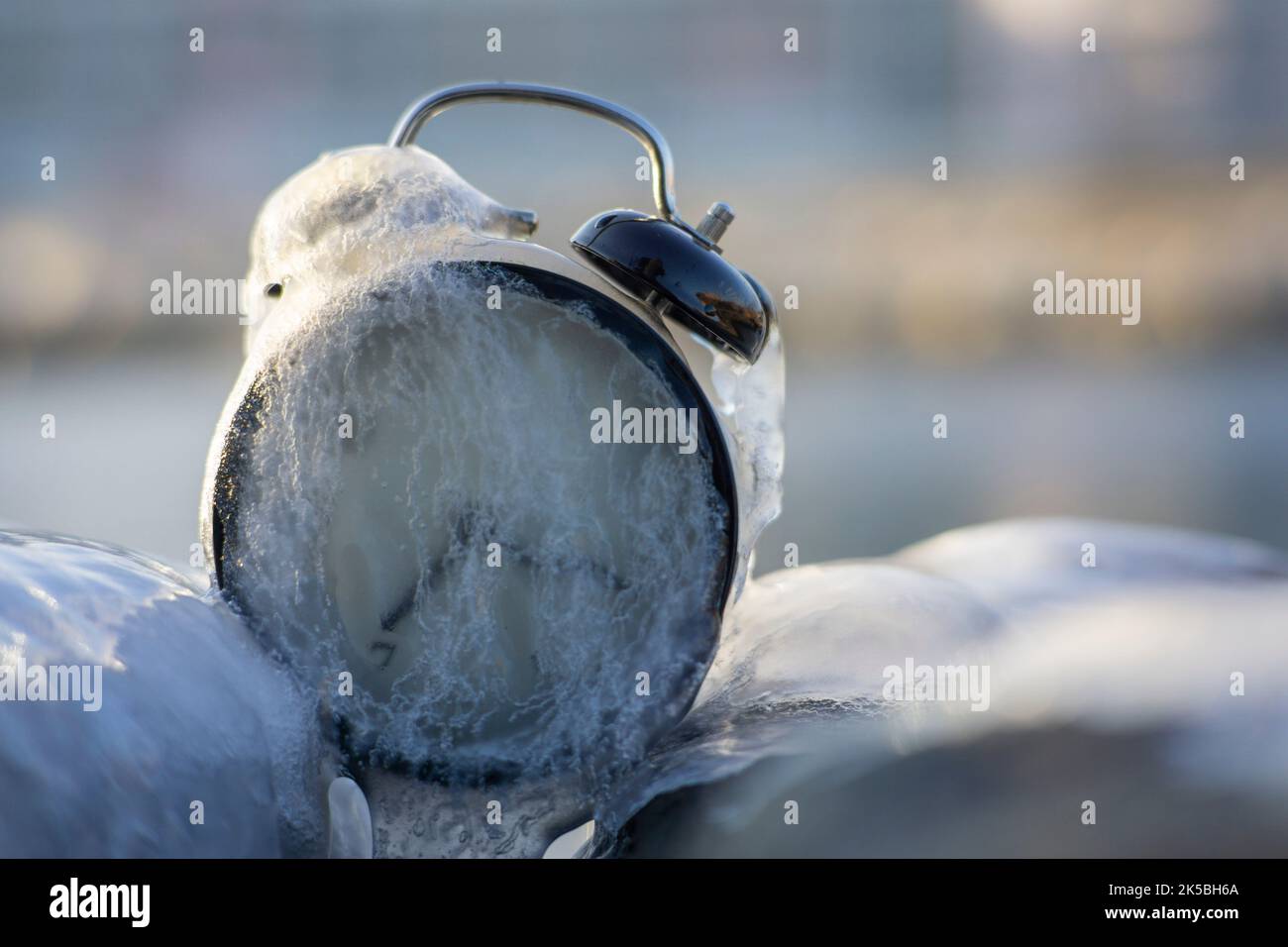 Tempo di congelamento. Un orologio congelato in ghiaccio. Situazione meteorologica estrema. Ora legale. Foto Stock