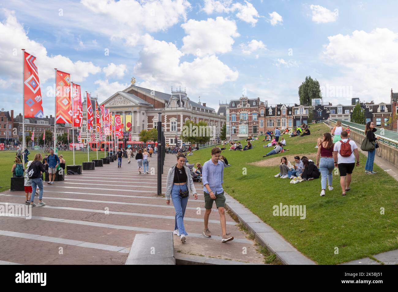 La gente del posto e i turisti possono trascorrere una giornata di sole nella piazza dei musei nella capitale olandese di Amsterdam. Foto Stock