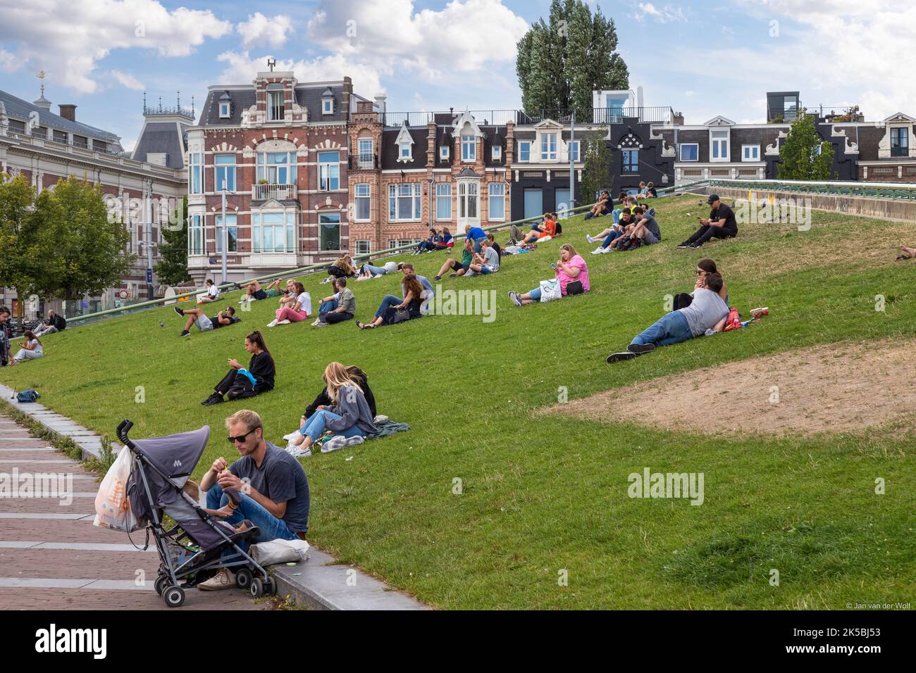 La gente del posto e i turisti possono trascorrere una giornata di sole nella piazza dei musei nella capitale olandese di Amsterdam. Foto Stock