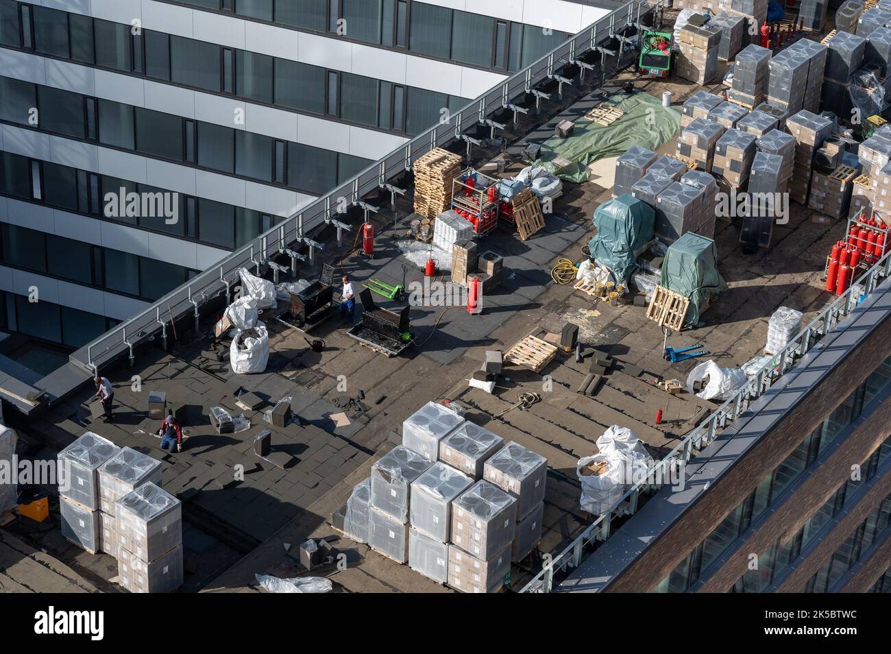 Vista ad occhio di uccello di un cantiere sul tetto. Impermeabilizzazione professionale del bitume su un edificio piano. Foto Stock