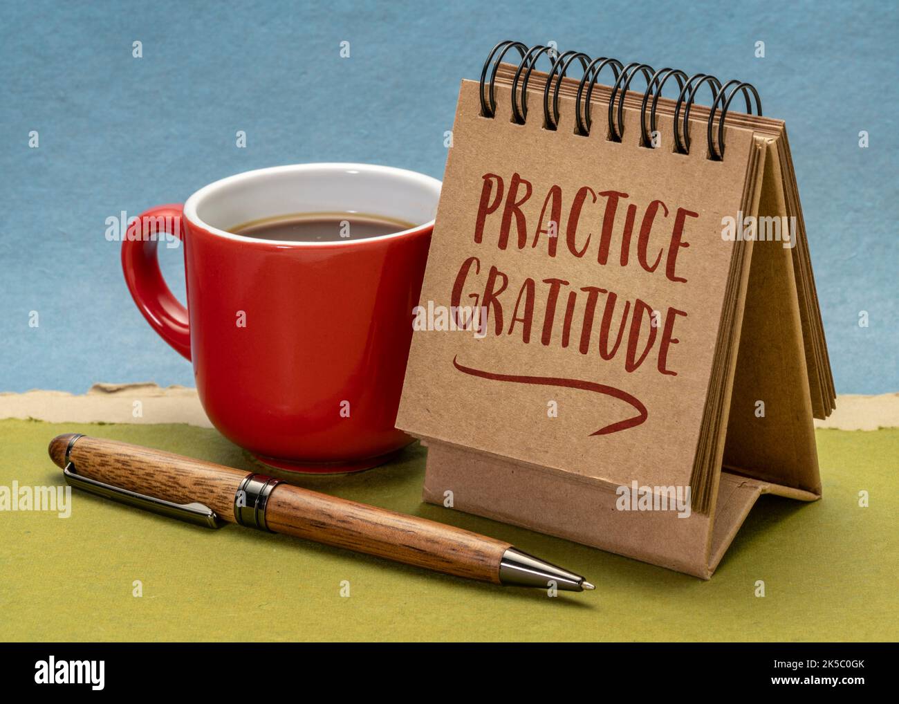 esercitarsi nella gratitudine nota di ispirazione - scrittura a mano in un piccolo calendario o notebook desktop Foto Stock