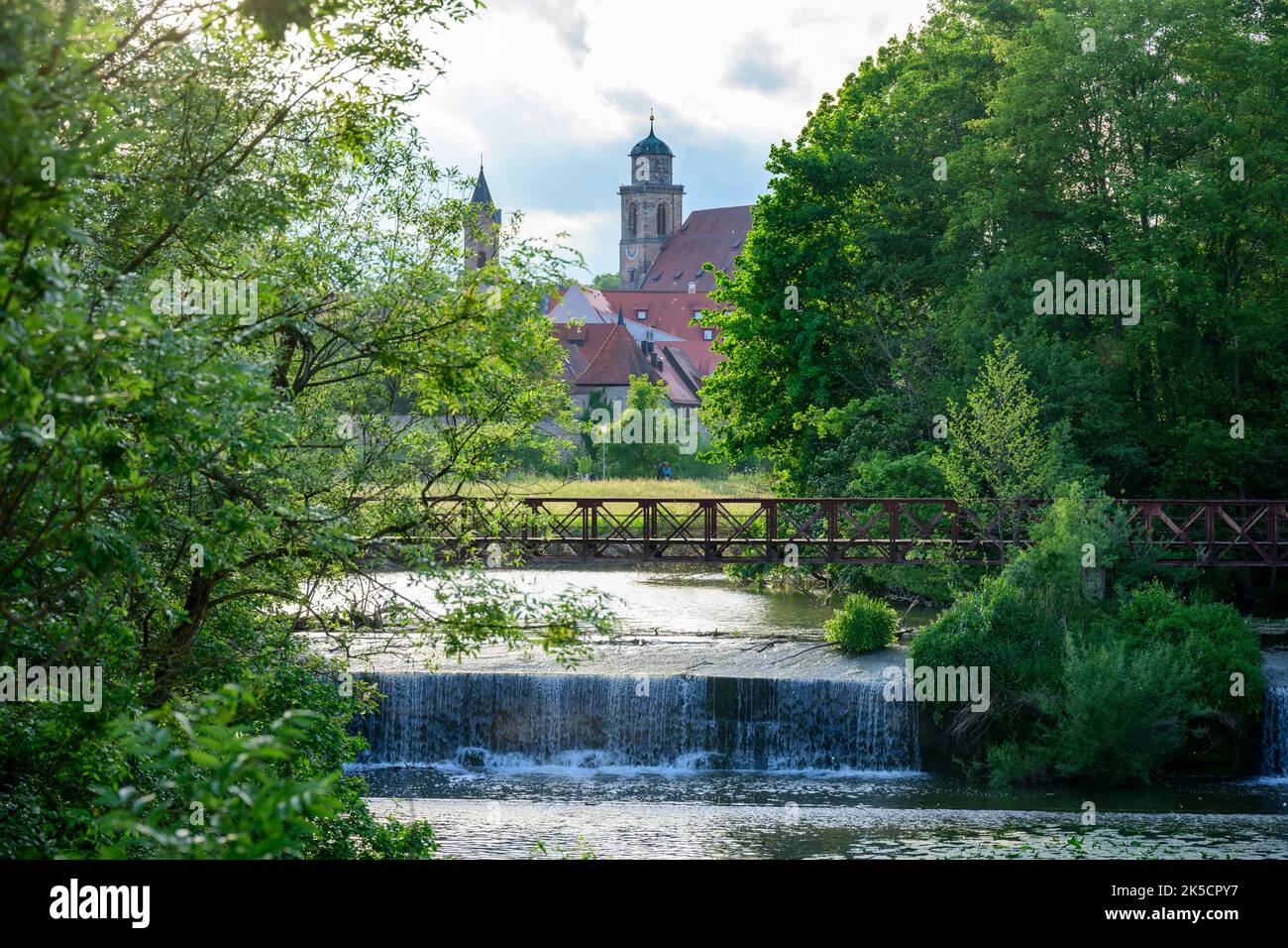 Germania, Baviera, Dinkelsbühl, il fiume Wörnitz con la cattedrale sullo sfondo. Foto Stock