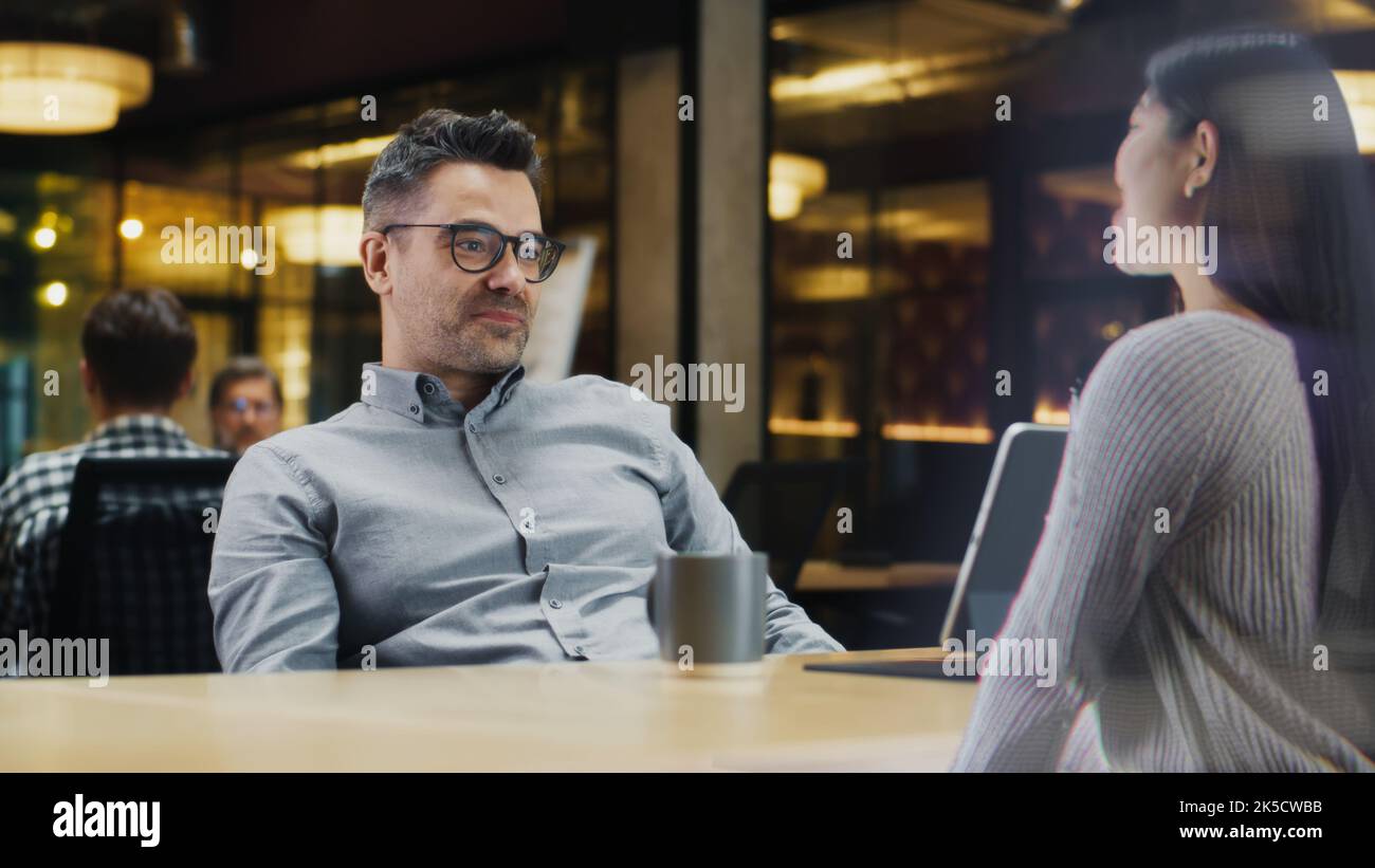 La donna parla alla chiamata con la sua amica utilizzando un software olografico. Ologramma di donna appare davanti all'uomo che riceve la chiamata. Effetti speciali VFX. Concetto di tecnologia futuristica. Foto Stock