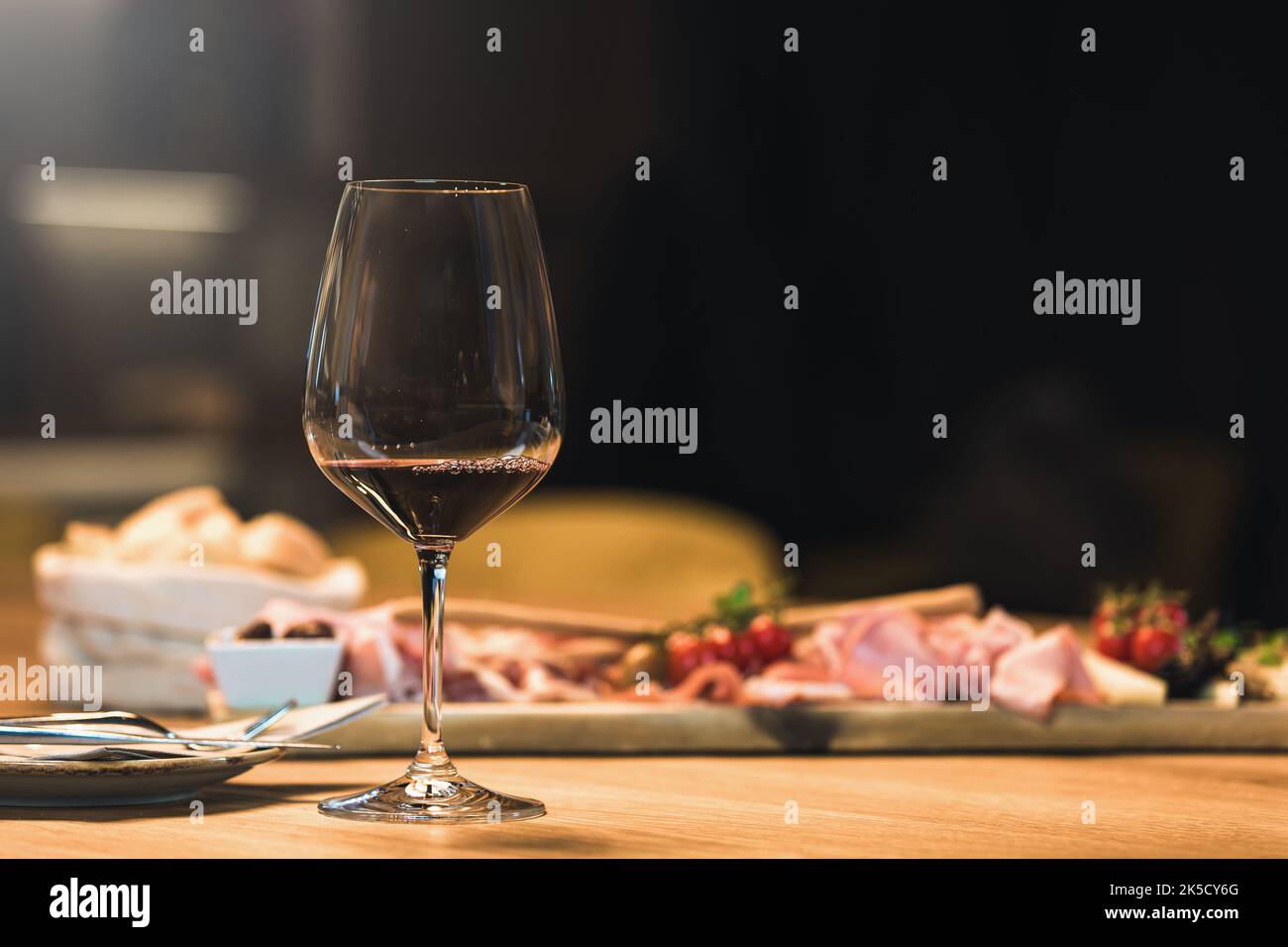 Si beve vino e si mangia carne fredda in una cantina. Foto Stock