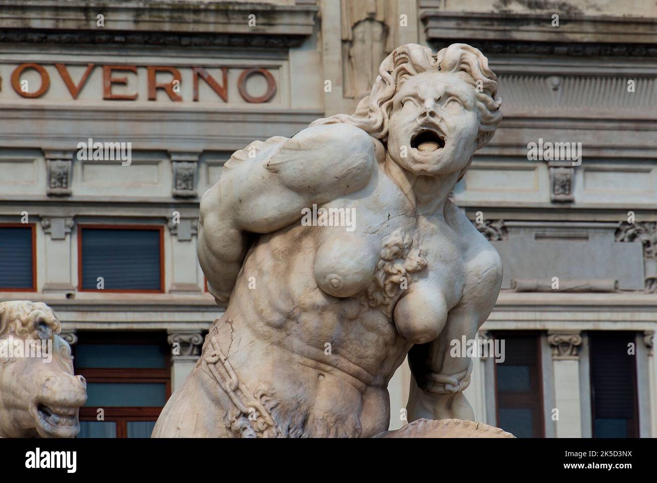 Sicilia, Messina, centro storico, fontana di Nettuno, figura marmorea di Charybdis, edificio storico sullo sfondo Foto Stock