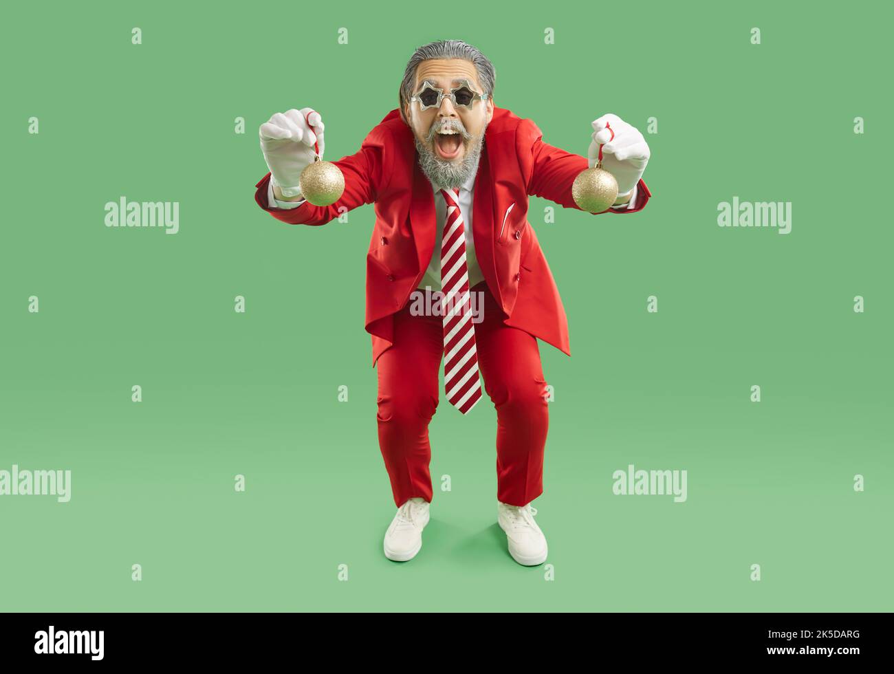 Uomo divertente in vestito rosso, cravatta e occhiali a forma di stella che si divertono alla festa di Natale Foto Stock