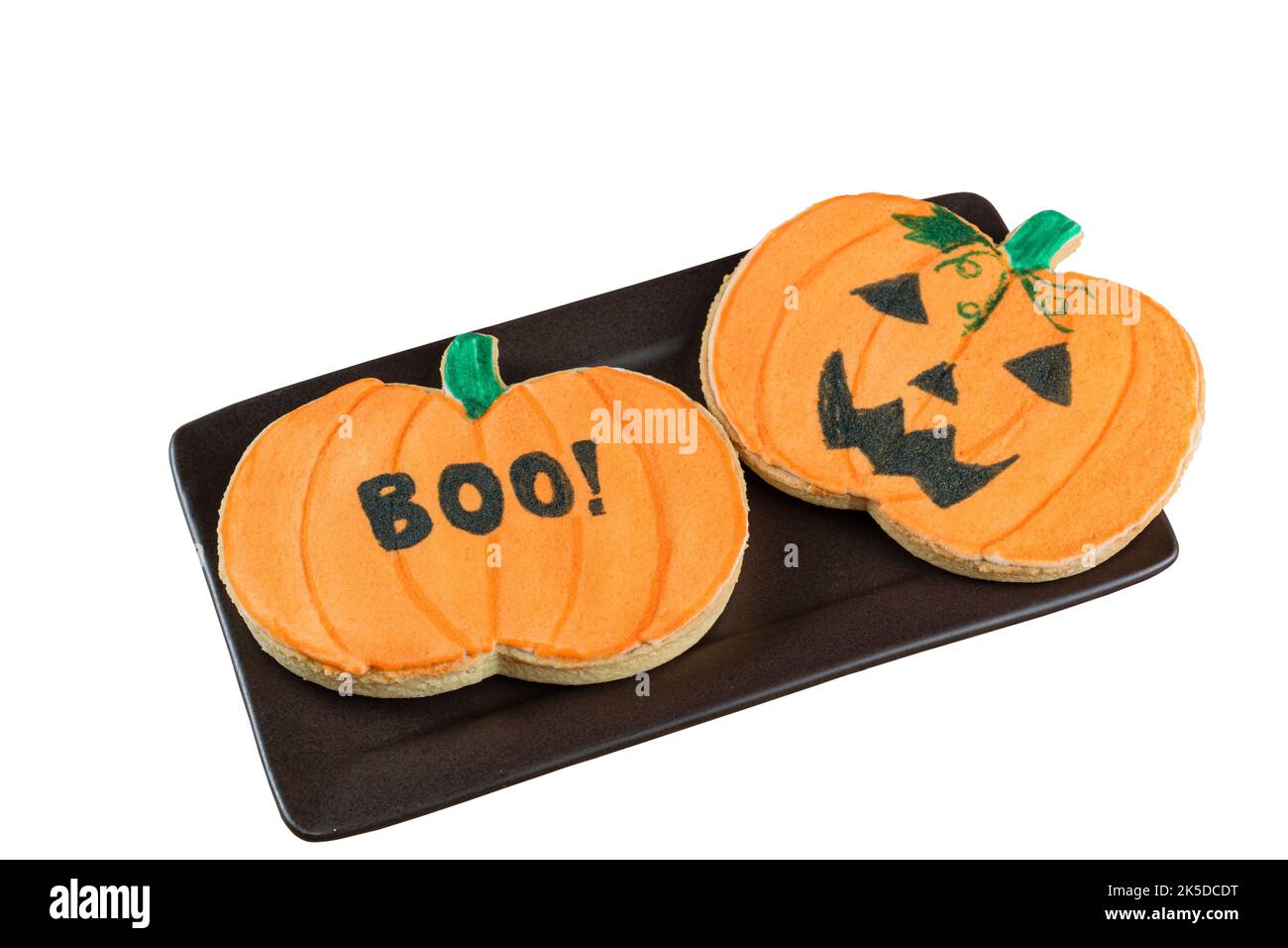 Biscotti al burro a forma di zucca su un piatto marrone (sfondo bianco). Foto Stock