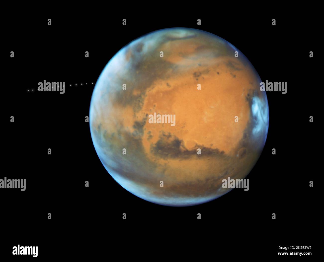 Marte. Il telescopio spaziale Hubble della NASA cattura anche la piccola luna Phobos durante il suo trekking intorno al pianeta Rosso. Scoperta nel 1877, la luna è così piccola che appare come una stella nelle immagini Hubble. Phobos orbita Marte in soli 7hrs e 39 minuti, che è più veloce di Marte ruota. L'orbita della luna si restringe molto lentamente, il che significa che alla fine si infranirà sotto la spinta gravitazionale di Marte, o si schianterà sul pianeta. Hubble ha impiegato 13 esposizioni in 22 minuti per creare un video temporizzato che mostra il percorso orbitale della luna.versione ottimizzata di un'immagine originale della NASA. Credito: NASA Foto Stock