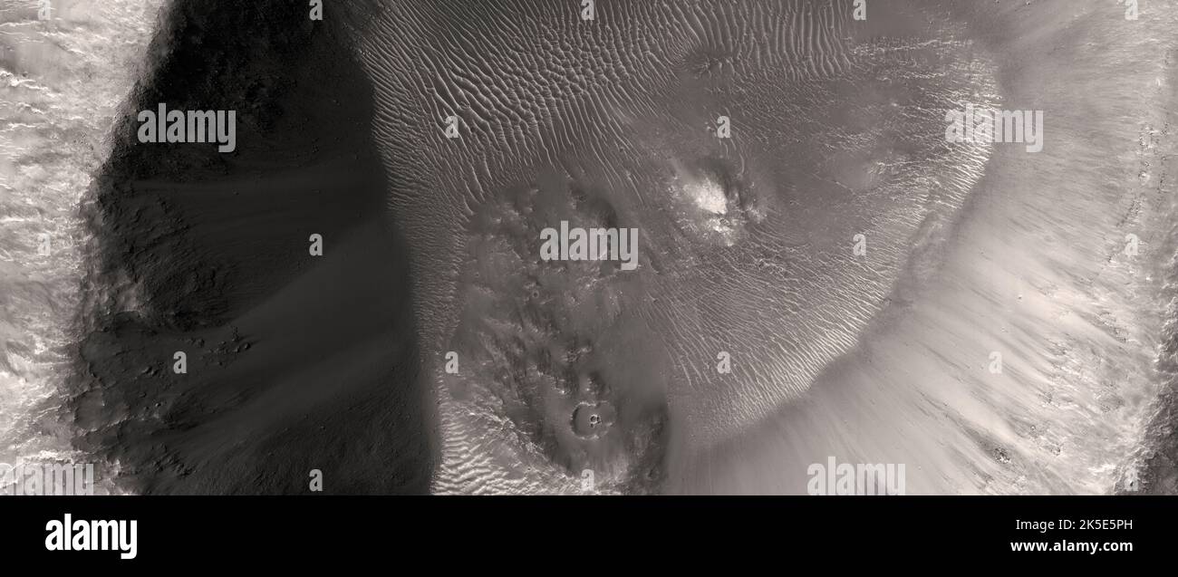 Paesaggio marziano. Questa immagine HiRISE di Hesperia Planum, Marte, mostra le argille nella parete di questo piccolo cratere (circa 5km), mentre il tumulo centrale ha un carattere spettrale diverso rispetto alle argille della parete. Questo è uno dei rari casi di tale evento e può suggerire attività idrotermica post-impatto in contrasto con le argille pre-esistenti che sono semplicemente scavate durante il processo di cratering.Image è di circa 5 km (3 mi) attraverso. Una versione ottimizzata e unica delle immagini NASA. Credit: ASA/JPL/UArizona Foto Stock