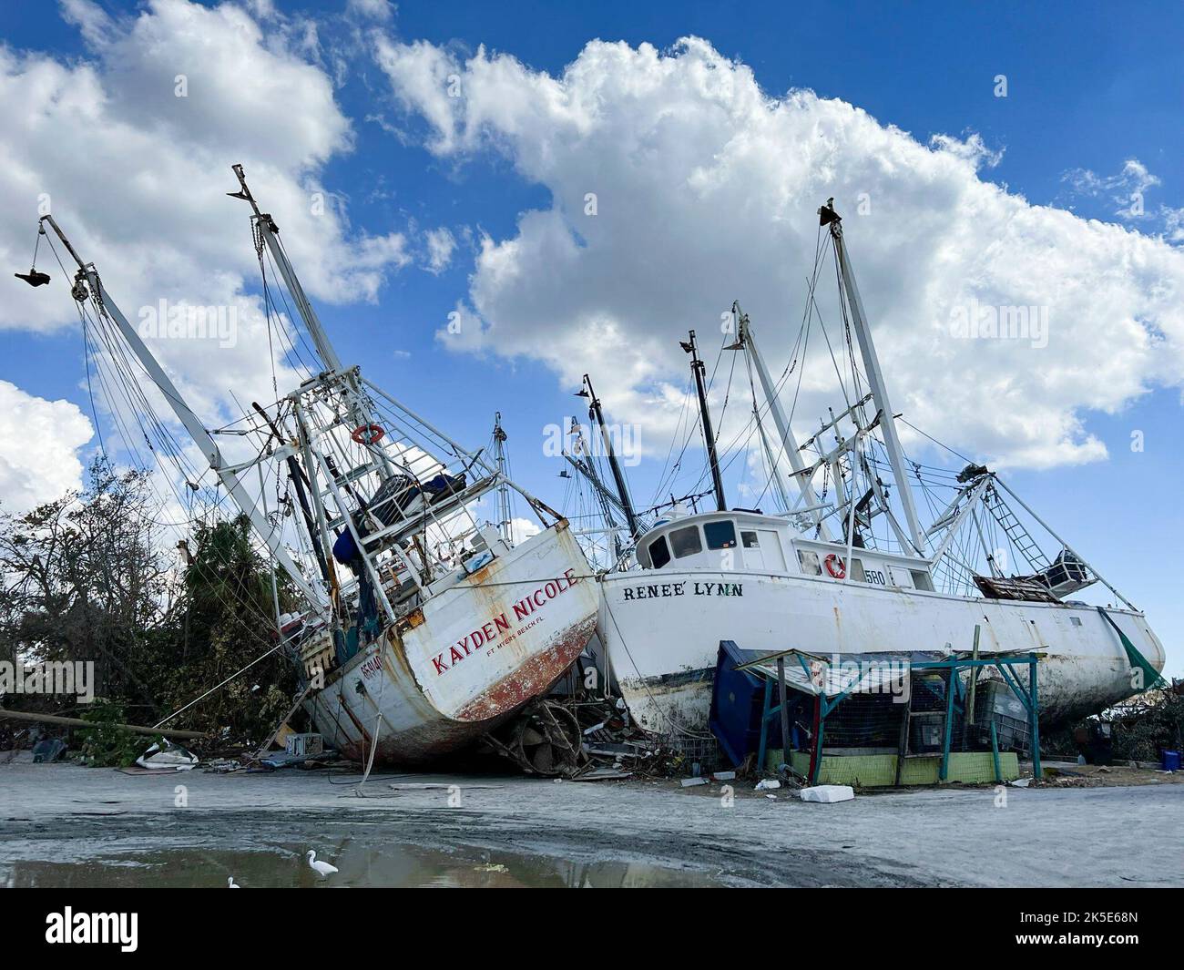 Le foto mostrano le barche danneggiate dei gamberetti e i detriti nel periodo successivo all'uragano Ian a Fort Myers. L'uragano Ian ha lasciato questo porticciolo di Fort Myers distrutto, con le barche che girano intorno e i moli polverizzati vicino ad un ponte a Fort Myers Beach. Foto Stock