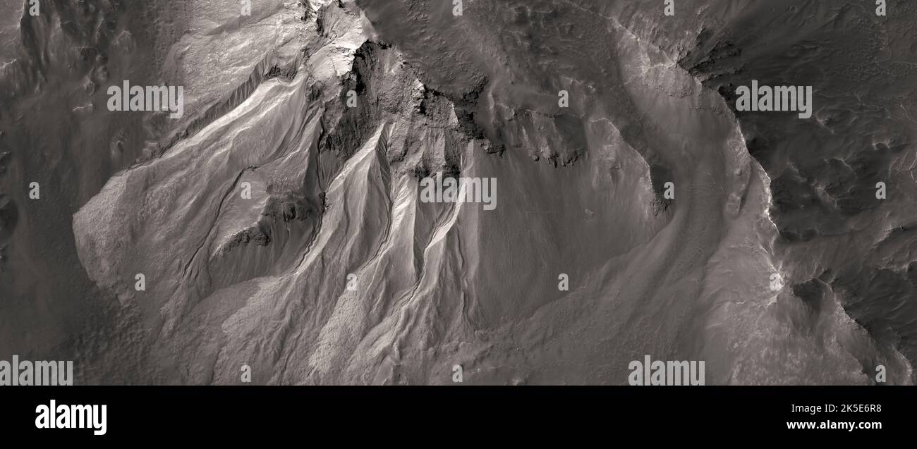 Paesaggio marziano. Questa immagine HiRISE mostra i canali sul bordo del cratere di Hale. Gli scienziati sono entusiasti di studiare queste caratteristiche perché, sulla Terra, di solito si formano attraverso l'azione di acqua liquida - a lungo pensato per essere assente sulla superficie marziana. In cima ai canali, grandi nicchie a forma di anfiteatro sono scolpite nella roccia. Il materiale rimosso da queste nicchie probabilmente è fluito in discesa verso i grembiuli attraverso i canali. L'immagine è meno di 5 km (3 mi) attraverso e si trova 258 km (160 mi) sopra la superficie. Una versione ottimizzata e unica delle immagini NASA. Credit: ASA/JPL/UArizona Foto Stock