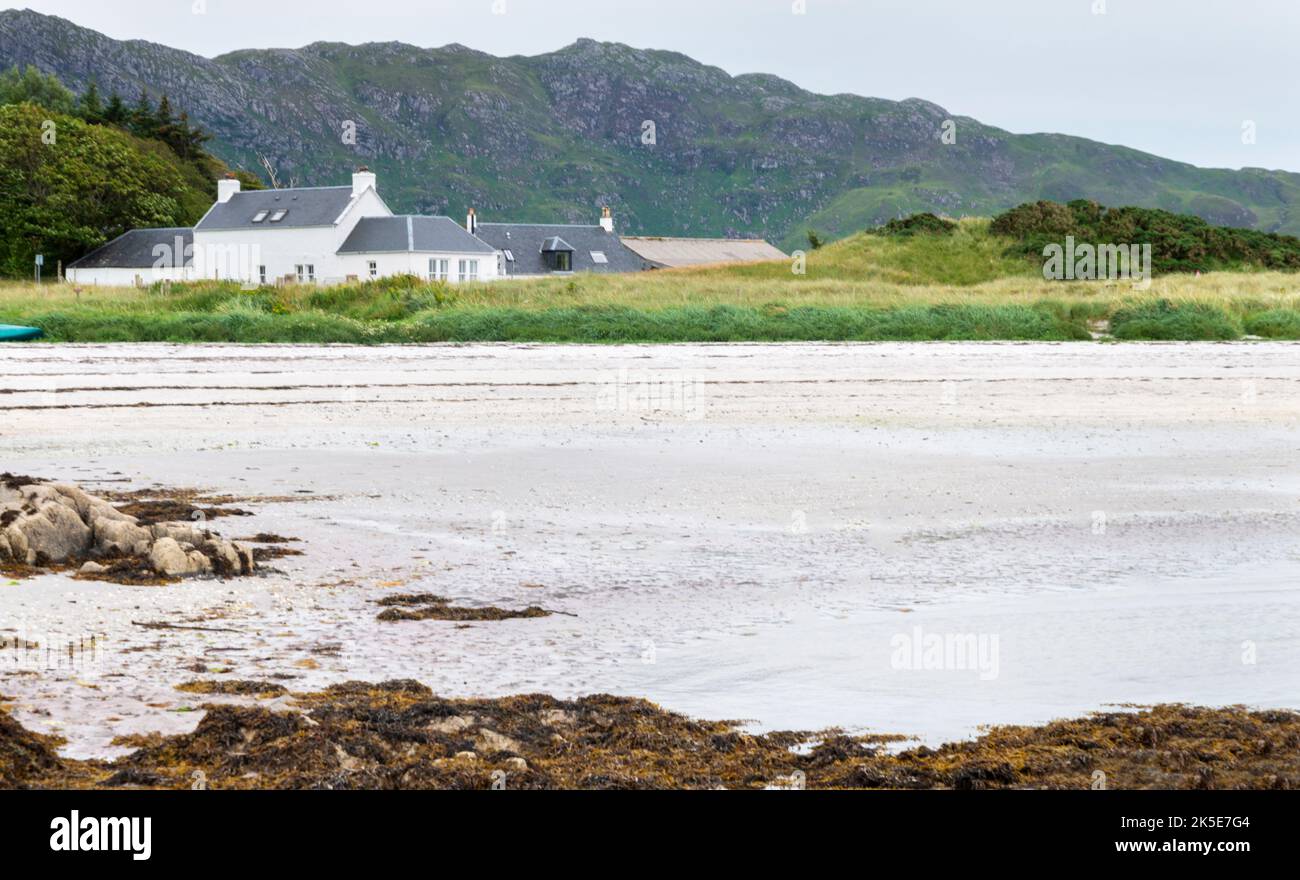 Arisaig,Inverness-shire,West Highlands,Scotland-Luglio 21 2022: La casa vacanze si trova al di là delle dune attraverso la distesa di sabbia bianca di questo remo Foto Stock