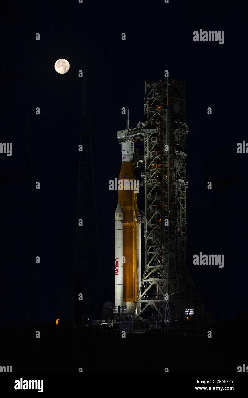 Una Luna piena è in vista dal Launch Complex 39B al Kennedy Space Center della NASA in Florida il 14 giugno 2022. Il sistema spaziale Artemis i Space Launch System (SLS) e la navicella spaziale Orion, in cima al lanciatore mobile, sono in preparazione per una prova di vestito bagnato per praticare le tempistiche e le procedure per il lancio. La prima di una serie sempre più complessa di missioni, Artemis i testerà SLS e Orion come sistema integrato prima dei voli con equipaggio per la Luna. Attraverso Artemis, la NASA atterrà la prima donna e la prima persona di colore sulla superficie lunare, spianando la strada ad una presenza lunare a lungo termine e utilizzando il Moo Foto Stock