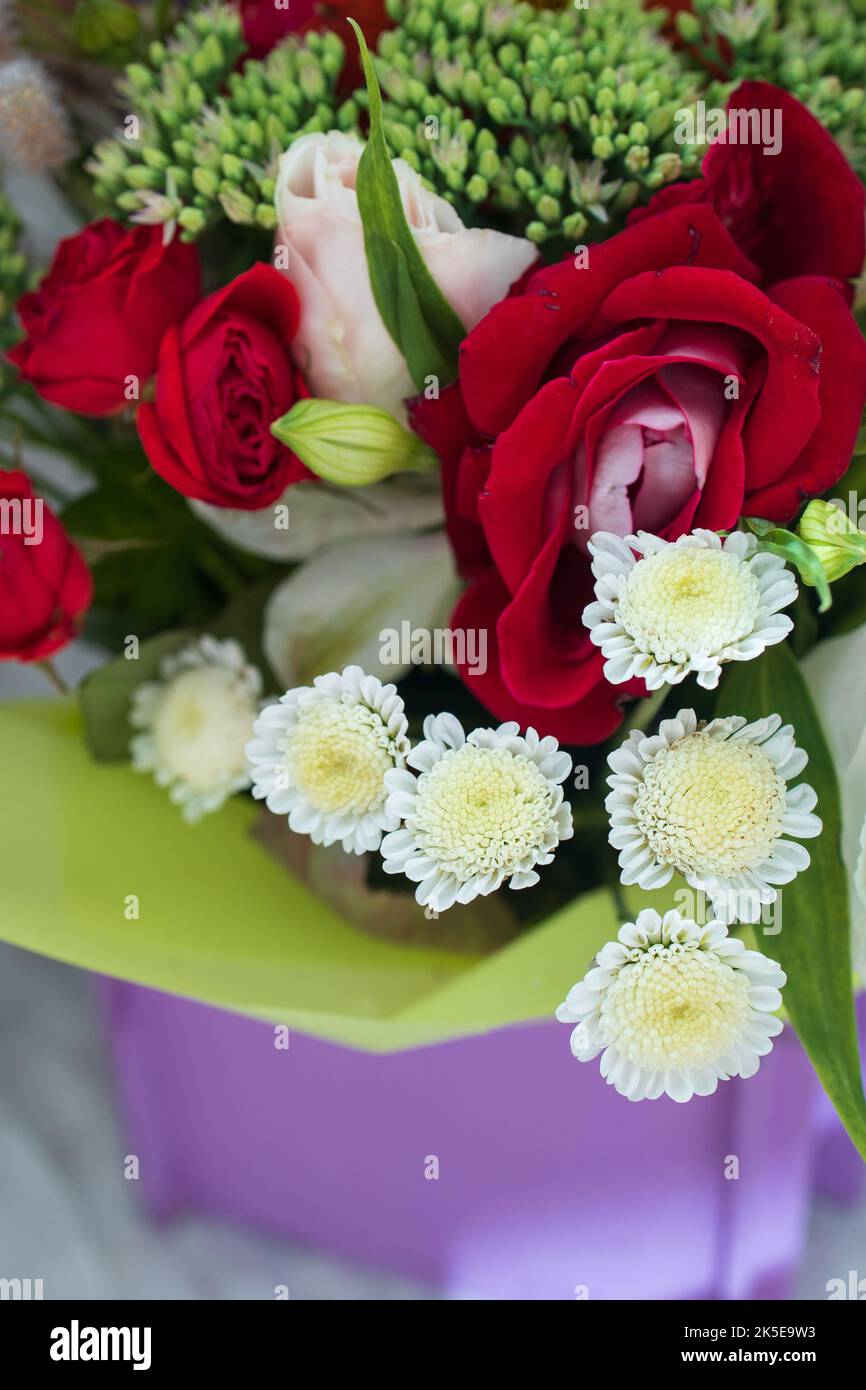 bel bouquet luminoso in un cesto viola su uno sfondo bianco, spazio copia. Foto Stock