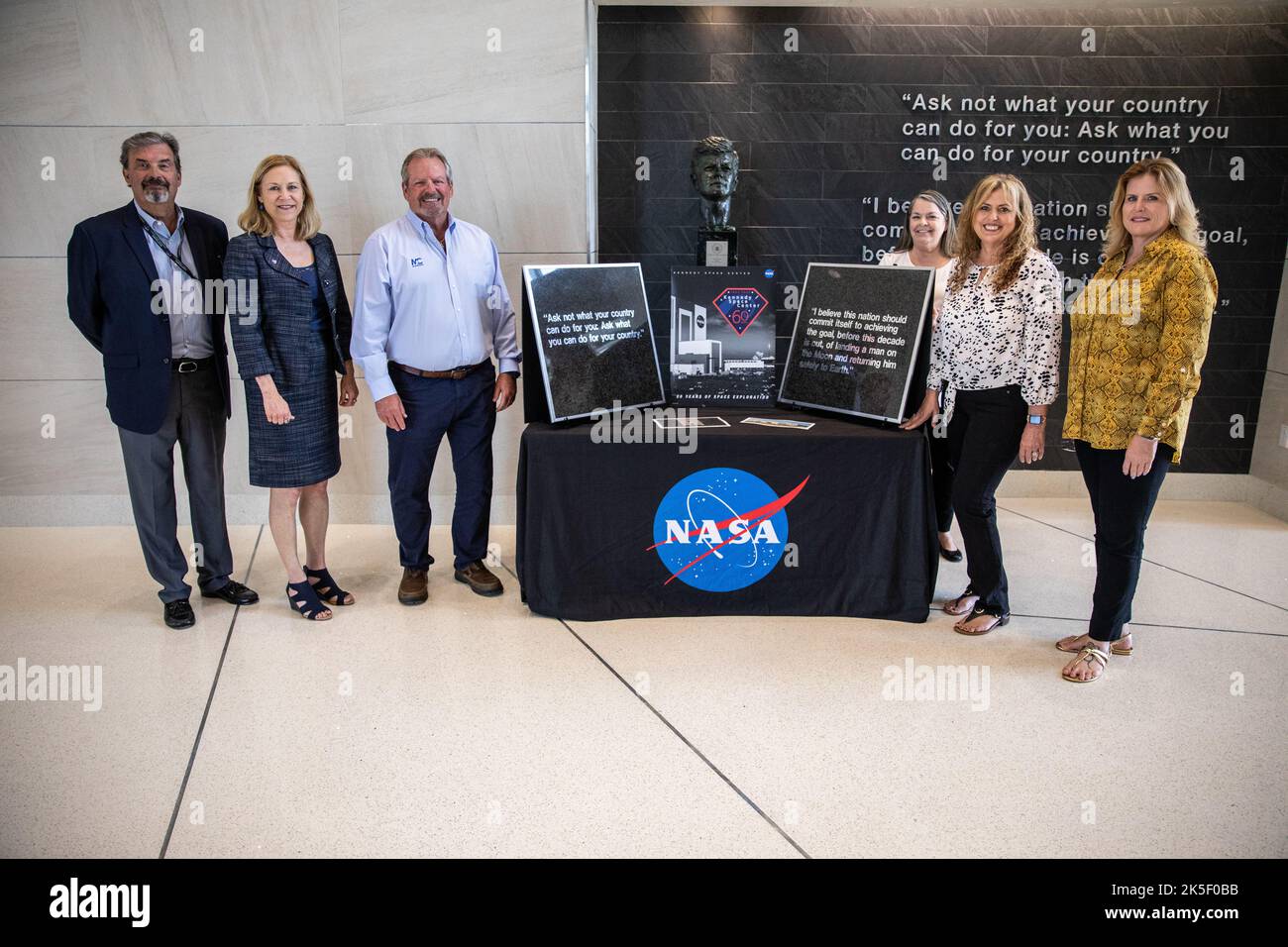 Janet Petro, direttore del Kennedy Space Center, propone con i dipendenti della Maverick Constructors all'interno della sede centrale del campus. La società ha presentato due piastrelle murarie conservate da 15 libbre in onore dei funzionari pubblici e degli appaltatori che hanno sostenuto la NASA. Foto Stock