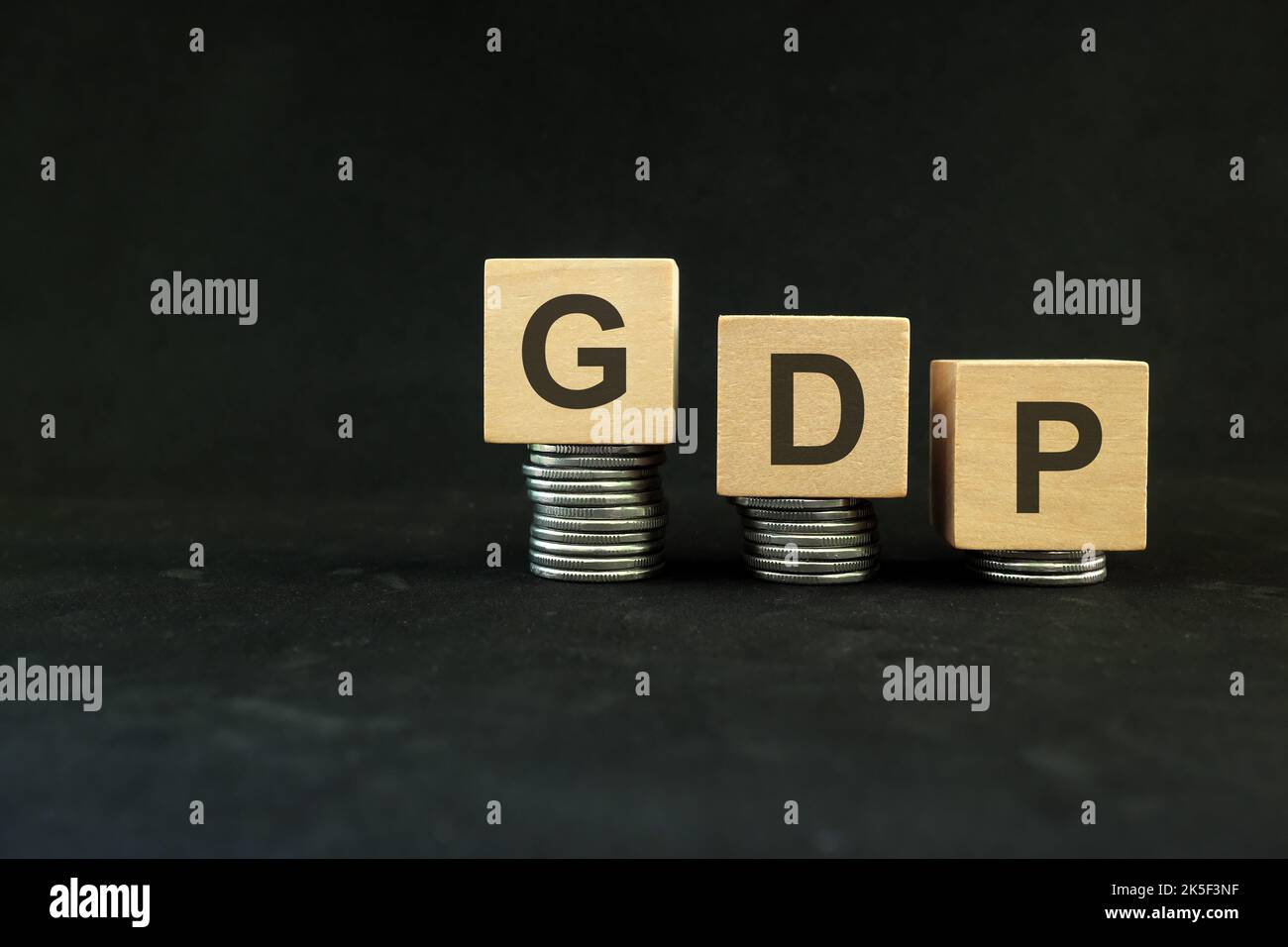 PIL o prodotto interno lordo in calo a causa di crisi concetto. Blocchi di legno su sfondo nero scuro. Foto Stock