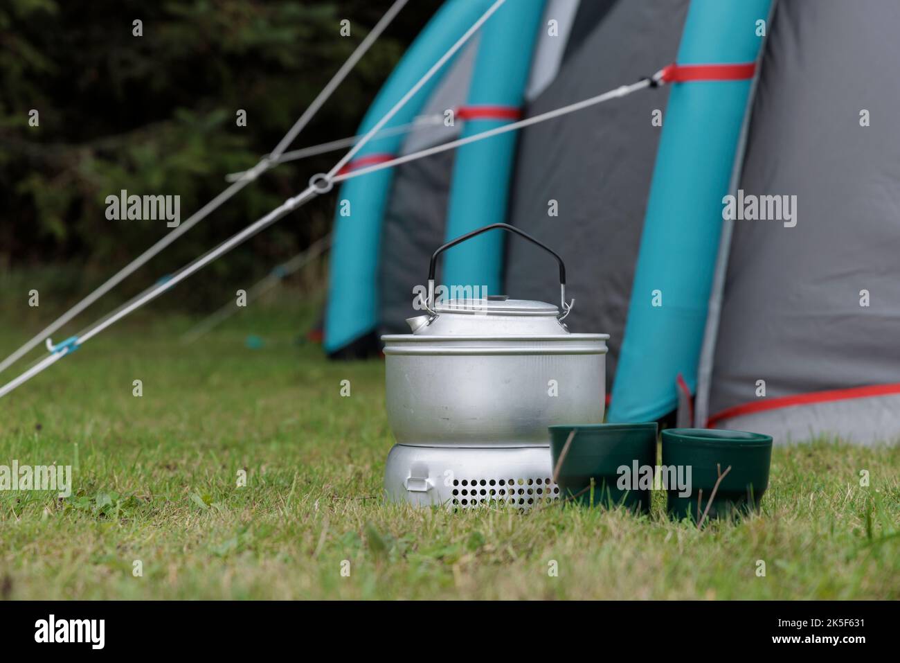 Stufa da campo, tazze e tenda. Foto Stock