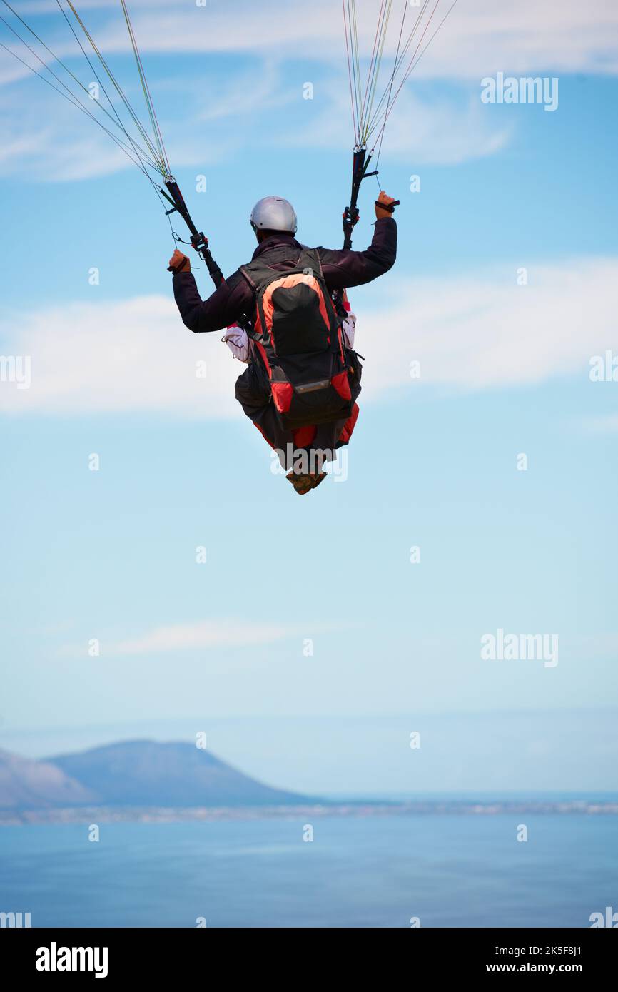 Il modo migliore per apprezzare questa visione. Vista posteriore di due giovani che fanno parapendio in tandem. Foto Stock