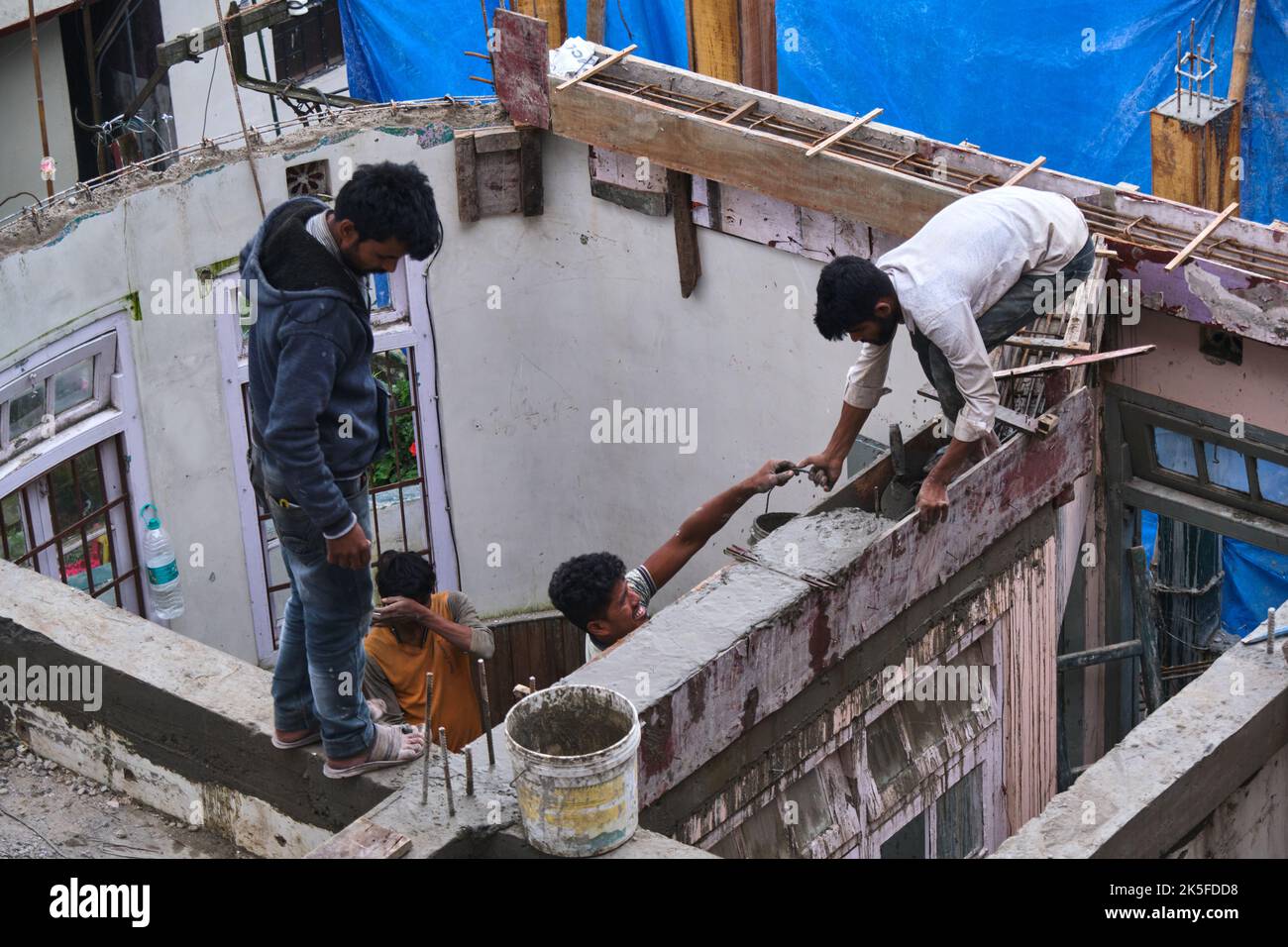 22 Giugno 2022, Darjeeling, India, lavoratore di costruzione indefinito che costruisce o costruisce il muro mettendo mattoni e cemento in darjeeling, India - conce Foto Stock