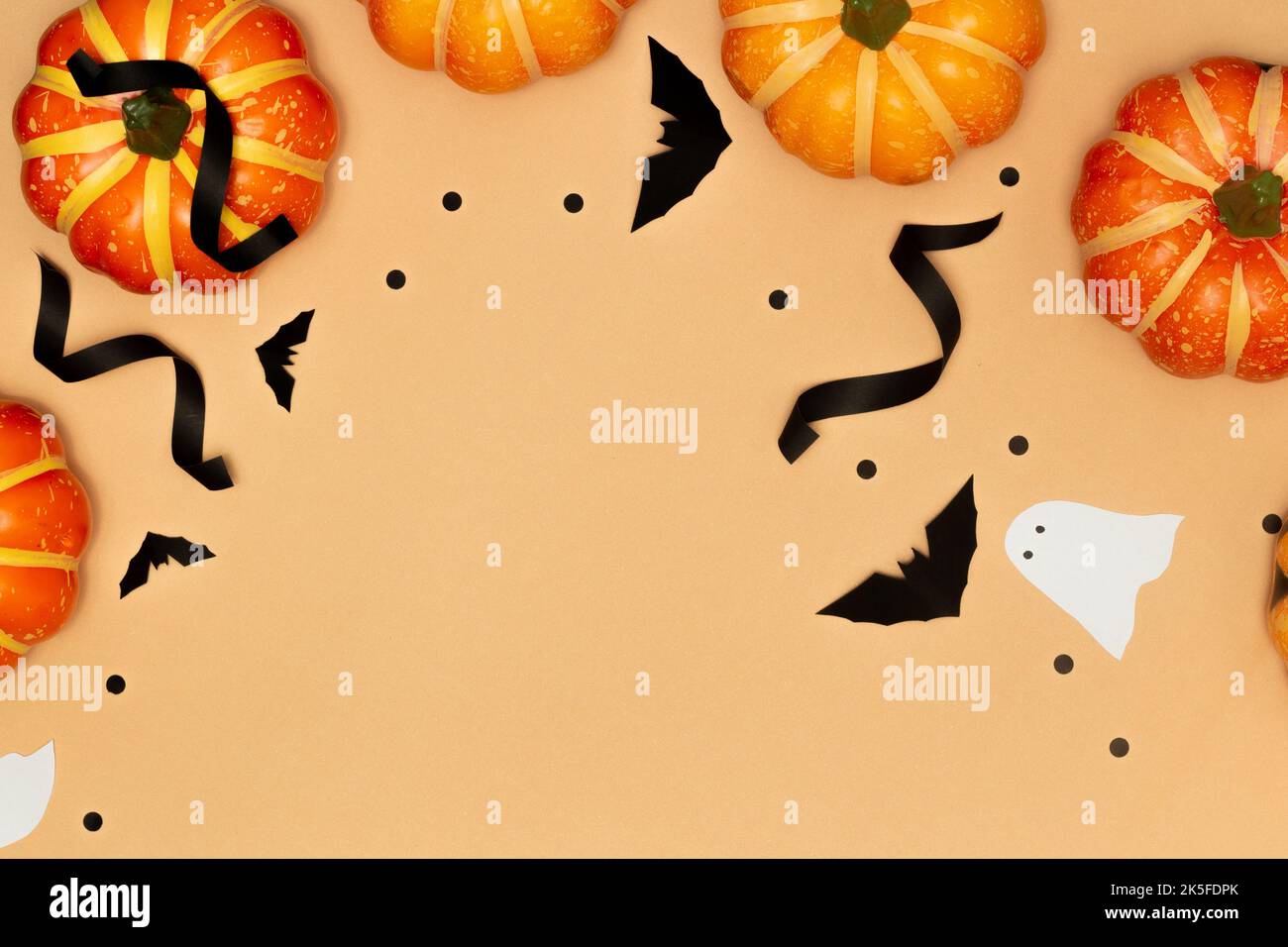 Halloween decorazione concetto, sorriso spaventoso zucche e fantasma con pipistrello nero su sfondo crema. Foto Stock