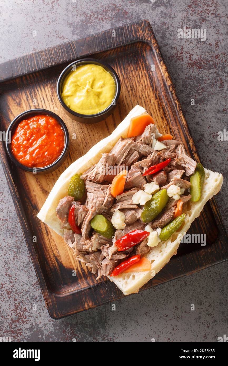 Paninoteca di manzo italiana in stile Chicago sul vassoio di legno sul tavolo. Vista verticale dall'alto Foto Stock