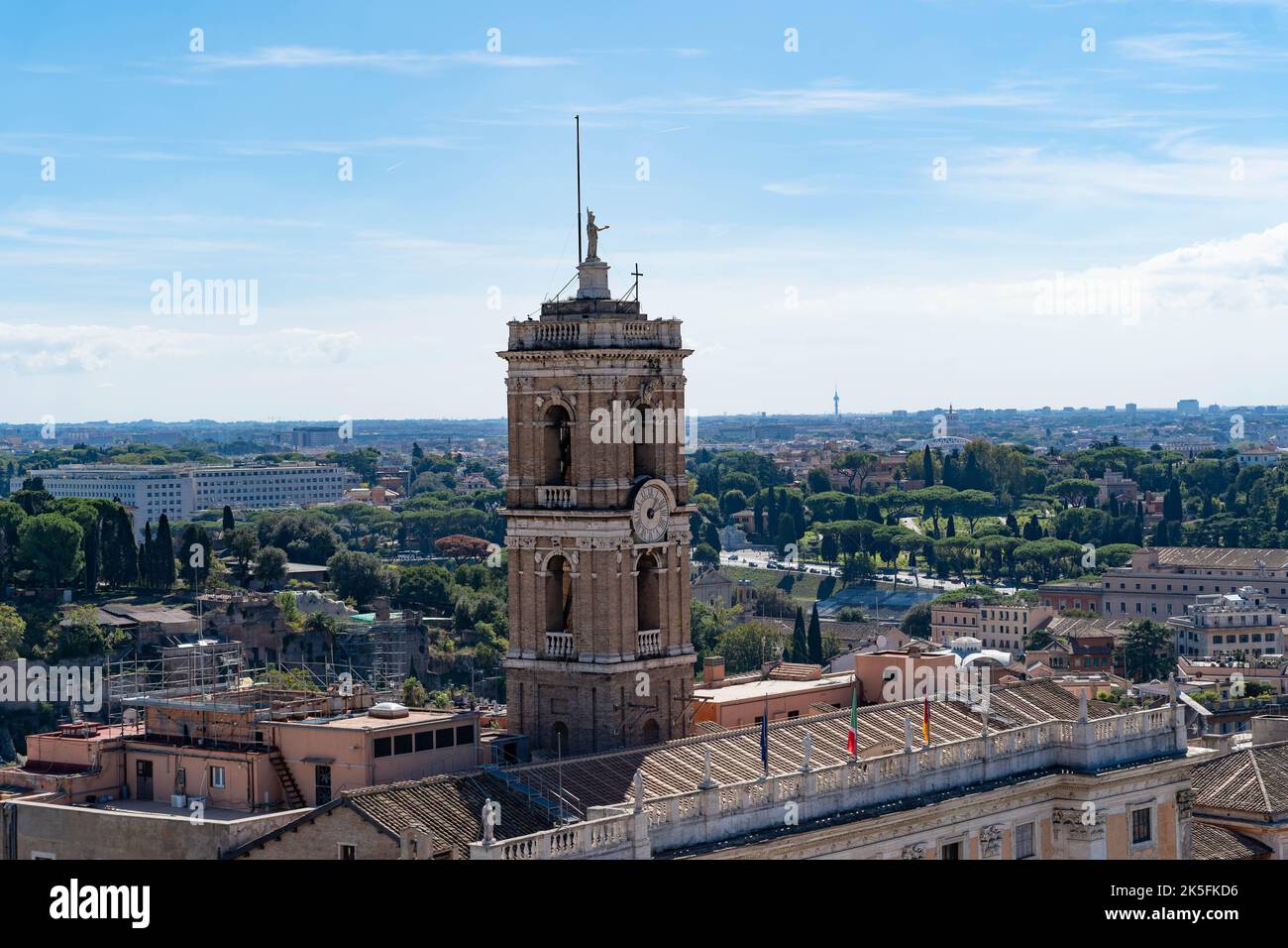 Storico campanile che si affaccia sul paesaggio urbano di Roma con un lussureggiante parco verde Foto Stock