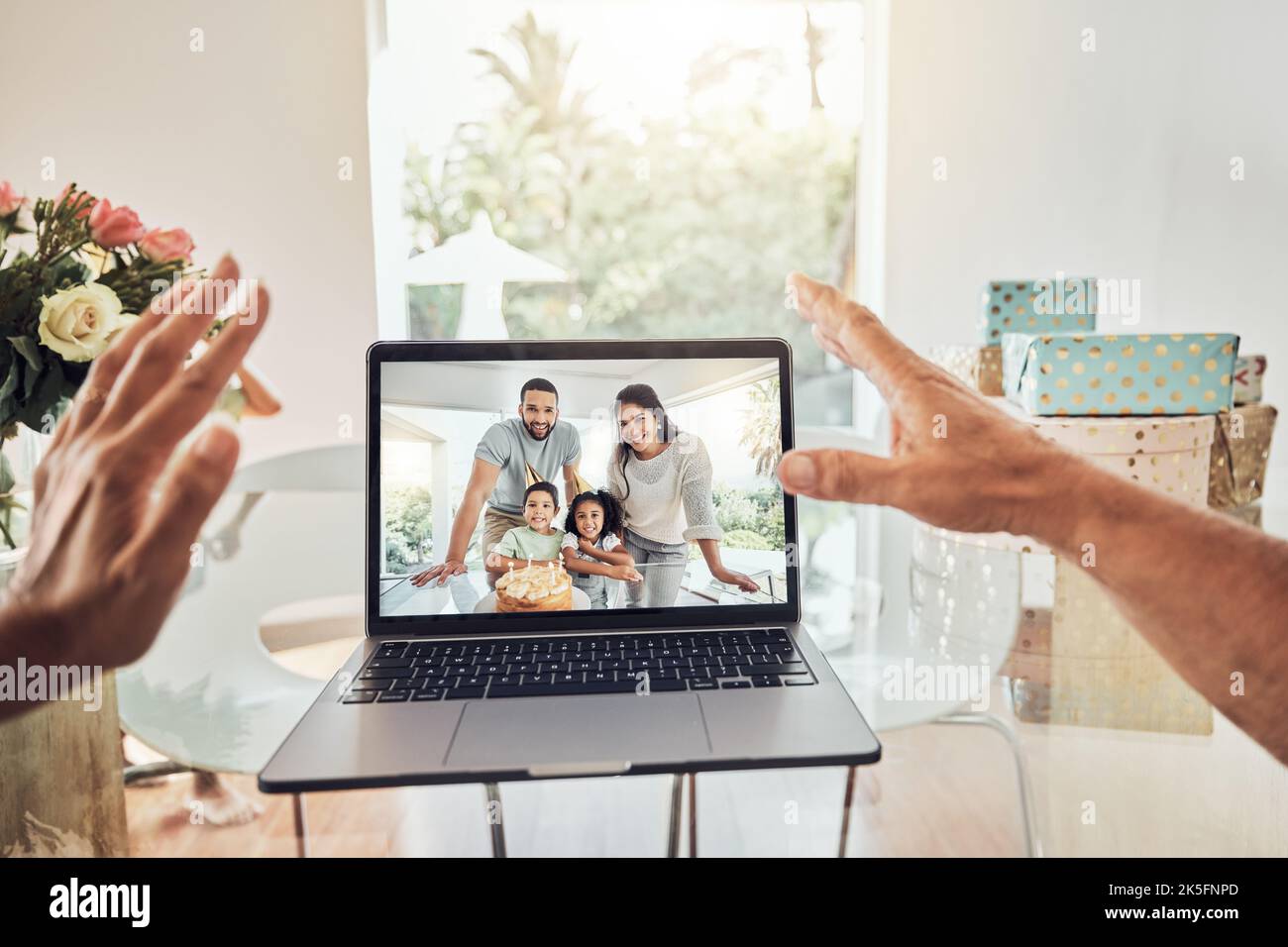 Mani, videochiamate e natale con la famiglia su un notebook con un'onda e chat online in una casa. Computer, internet e tecnologia con una madre, padre Foto Stock
