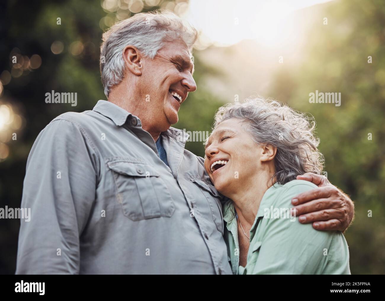 Coppia anziana, all'aperto e ridendo nella natura mentre si è attivi in avventura escursionistica o all'aperto per una passeggiata godendo l'amore e l'aria fresca. Buon vecchio e. Foto Stock