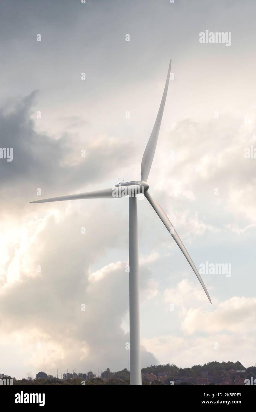 Eolico turbina elettrica pulita e verde energia rinnovabile generazione con un cielo drammatico dietro. Foto Stock