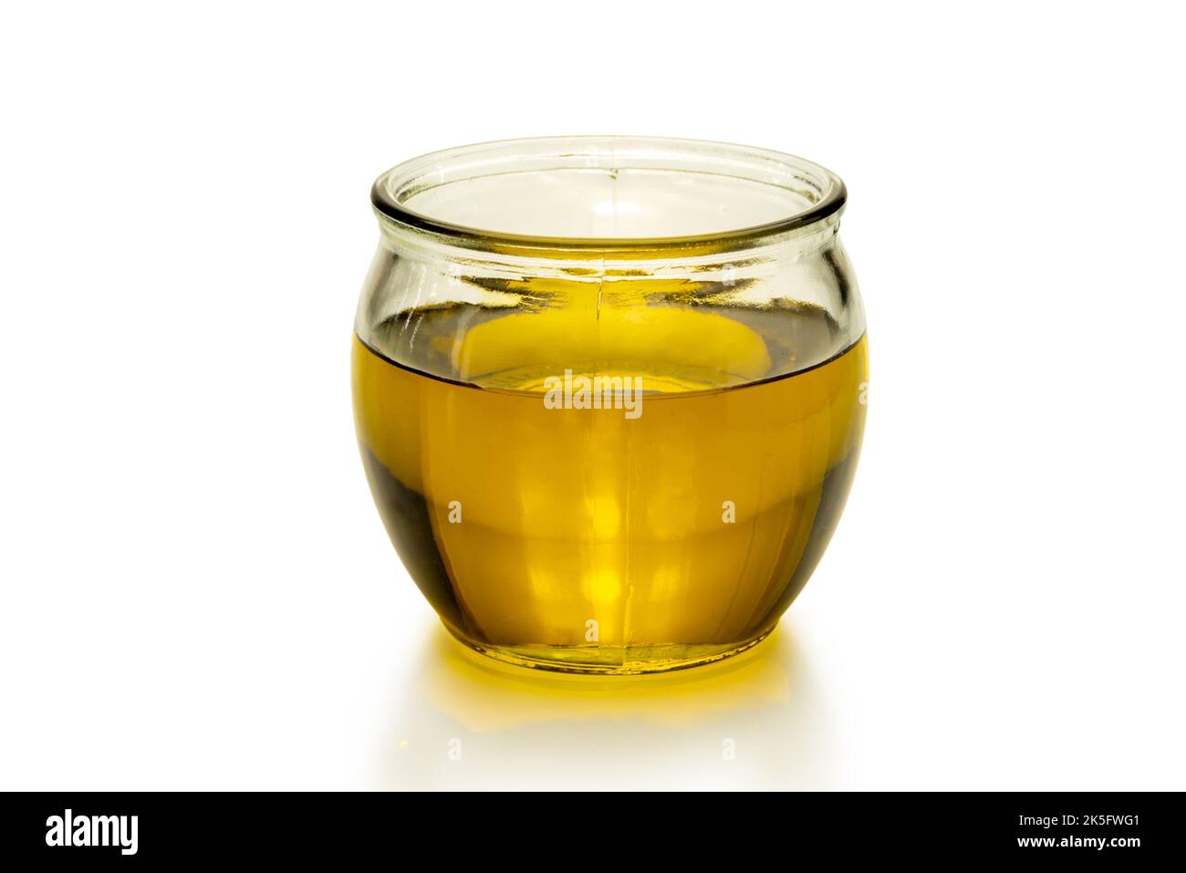 Olio extravergine di oliva in una ciotola di vetro isolata su bianco, filo di taglio Foto Stock