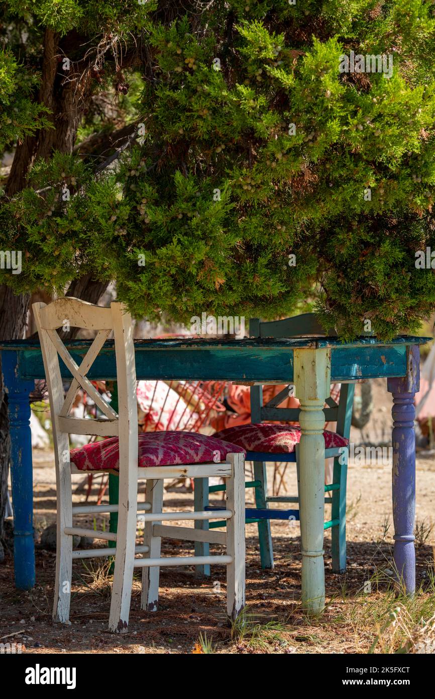 tavolo e sedie eleganti e squallidi in un ristorante greco, mobili rustici in angoscia al ristorante per le vacanze, sport ombroso alla taverna greca, vecchie sedie di legno Foto Stock