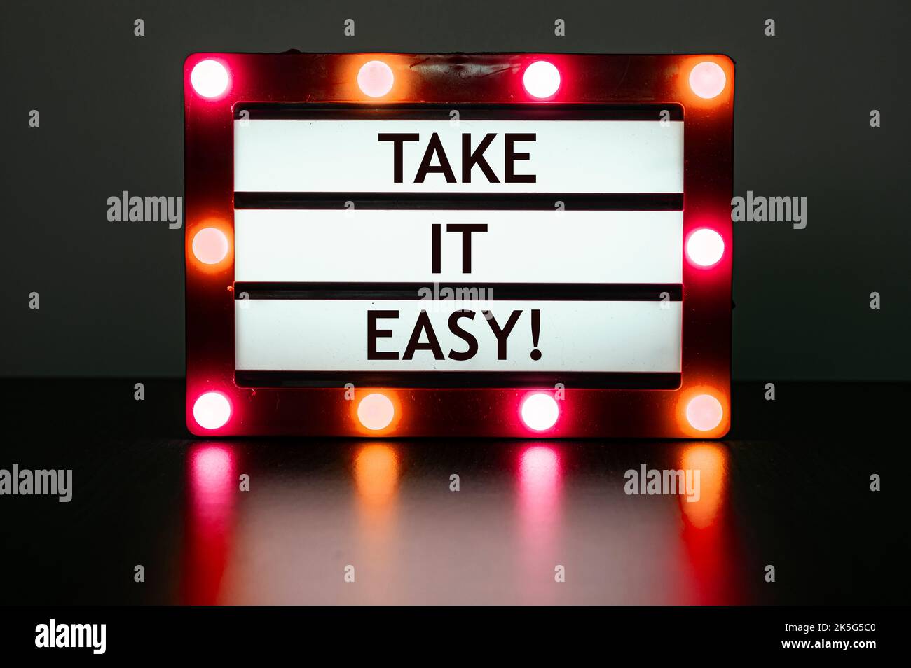 Lightbox con luci rosse in stanza scura con frase-Take it easy. Foto Stock