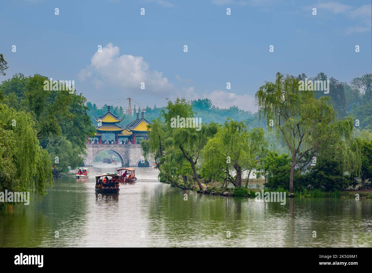 Yangzhou, Jiangsu, Cina. Imbarcazioni da diporto avvicinando cinque Pavilion Bridge, snello West Lake Park. Foto Stock