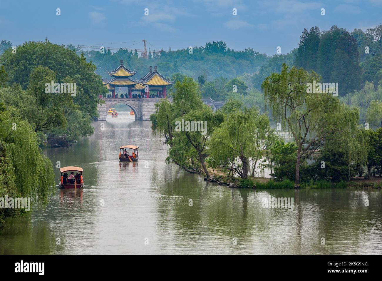 Yangzhou, Jiangsu, Cina. Imbarcazioni da diporto avvicinando cinque Pavilion Bridge, snello West Lake Park. Foto Stock