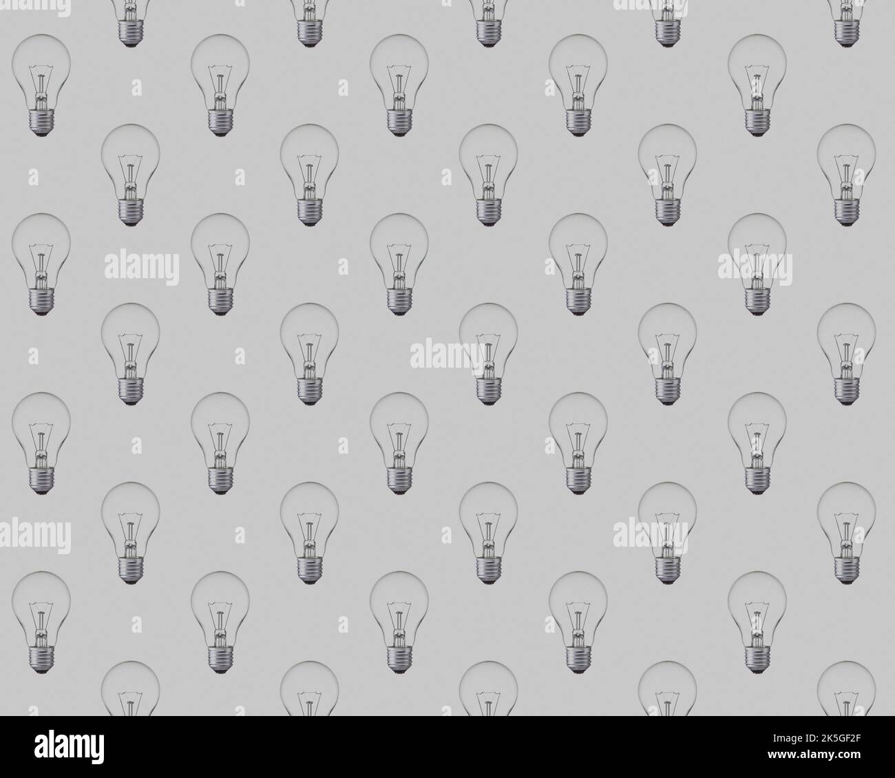 Schema senza cuciture di lampadine non illuminate su sfondo grigio. Illustrazione del concetto di risparmio energetico e di risparmio energetico. Foto Stock