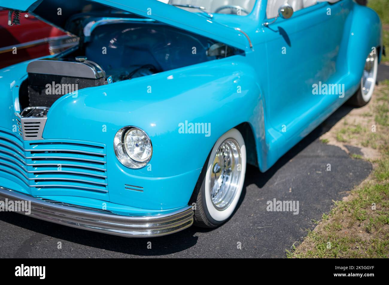 VIVID cielo blu antica auto decappottabile d'epoca con top down e cofano aperto in una mostra di auto in Minnesota in piena luce del sole. Immagine del faro anteriore sinistro e del parafango. Foto Stock