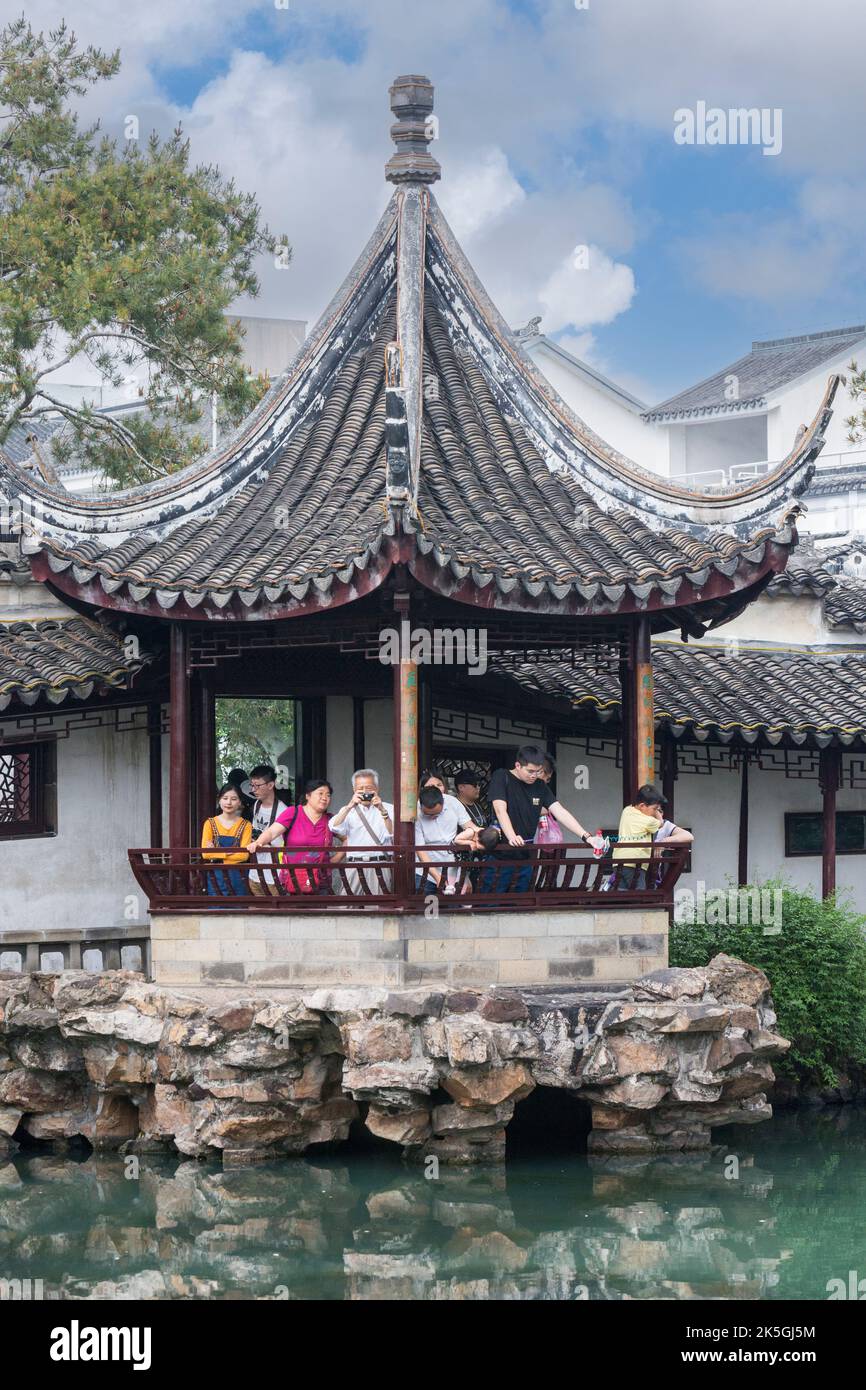Suzhou, Jiangsu, Cina. I turisti nel padiglione affacciato sul laghetto in giardino, la casa del Maestro delle reti. Foto Stock