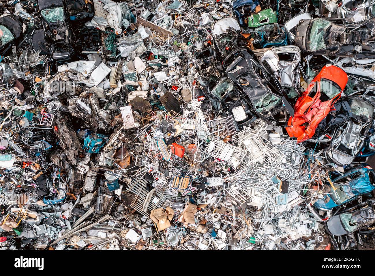 Vista aerea direttamente sopra una grande pila di rottami di metallo e di auto frantumate presso un deposito di rottami di metallo del concessionario Foto Stock
