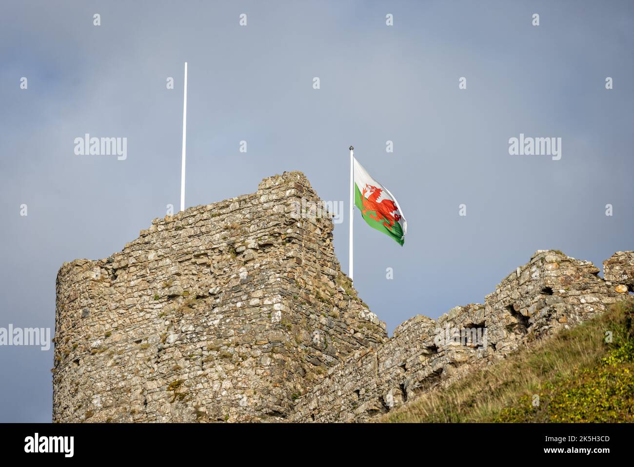 Primo piano delle battaglie del castello di Criccieth con la bandiera gallese che vola a Criccieth, Gwnydd, Galles, il 2 ottobre 2022 Foto Stock