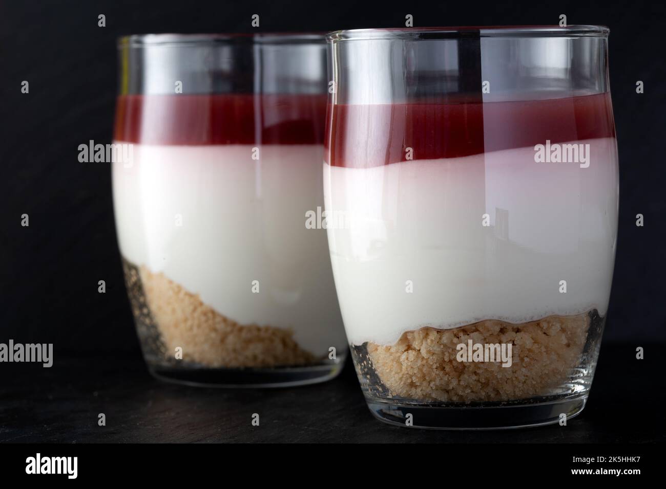 Dolce di lampone in vetro su ardesia scura - vista ravvicinata Foto Stock