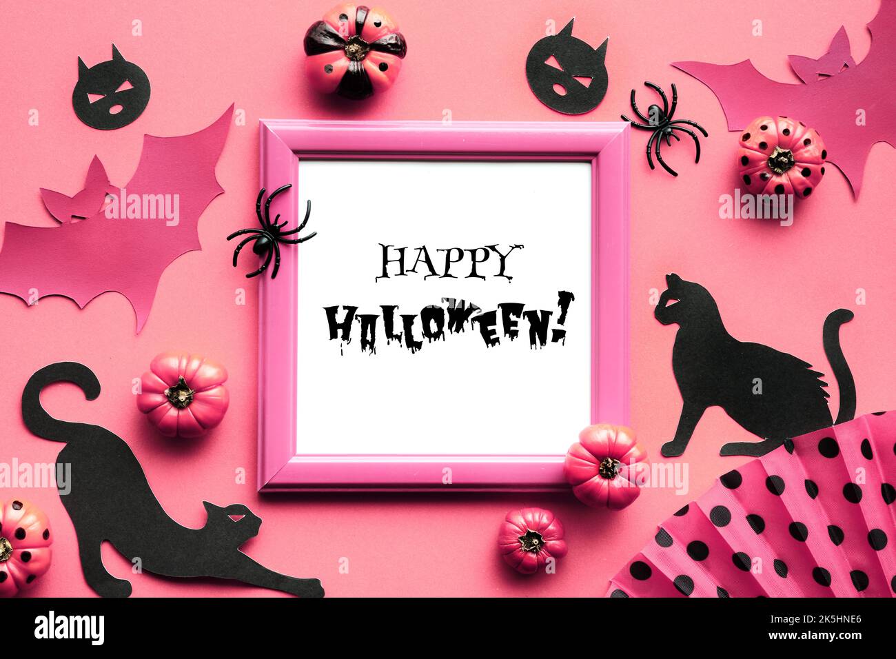Sfondo rosa di Halloween. Gatti neri, silhouette pipistrelli e ragni neri. Zucche decorative rosa e ventaglio con motivi geometrici, pois di polka. F Foto Stock