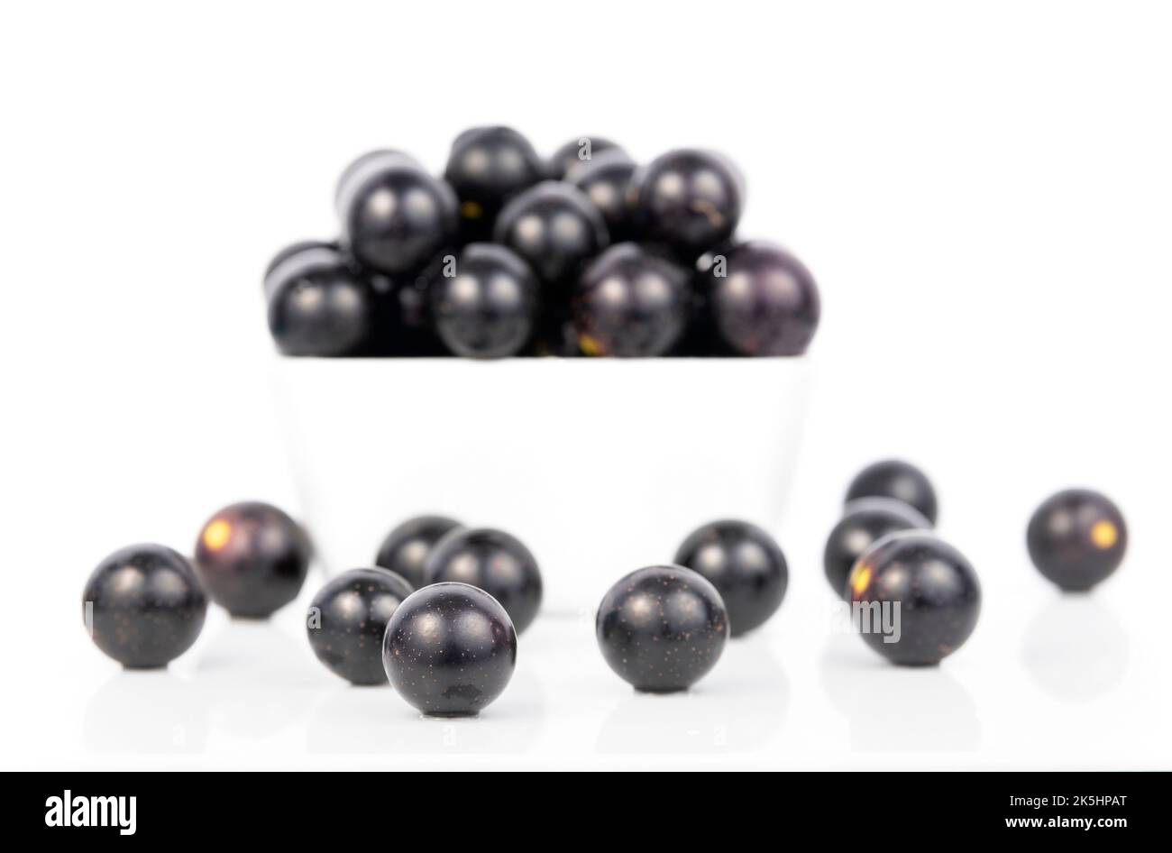 Uva Muscadine dentro e intorno A Una ciotola bianca quadrata, sfondo bianco, Noble Foto Stock