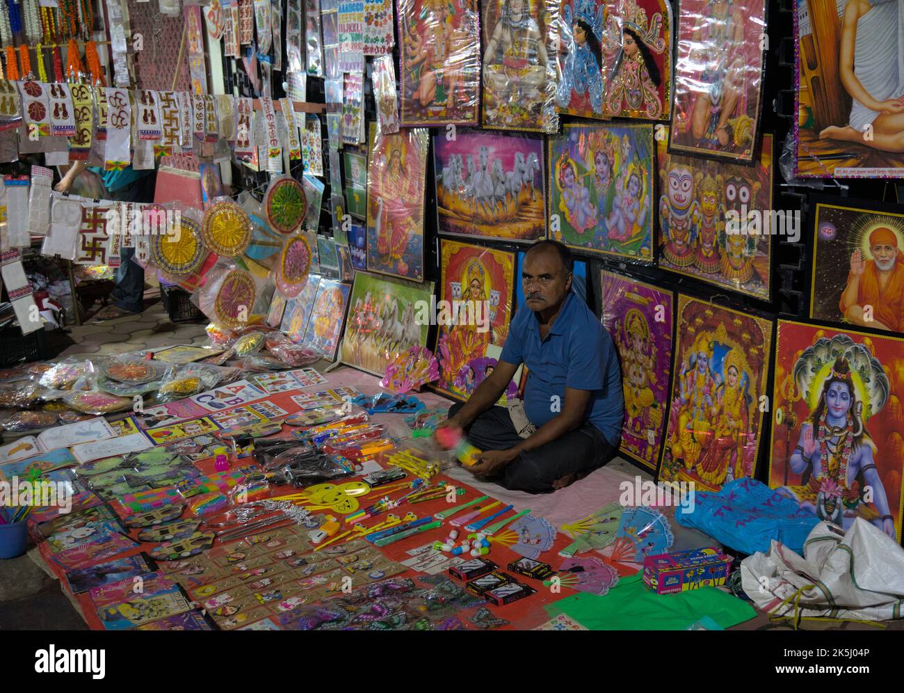 Venditore stradale che vende articoli decorativi in bancarelle temporanee pavimentazione Foto Stock